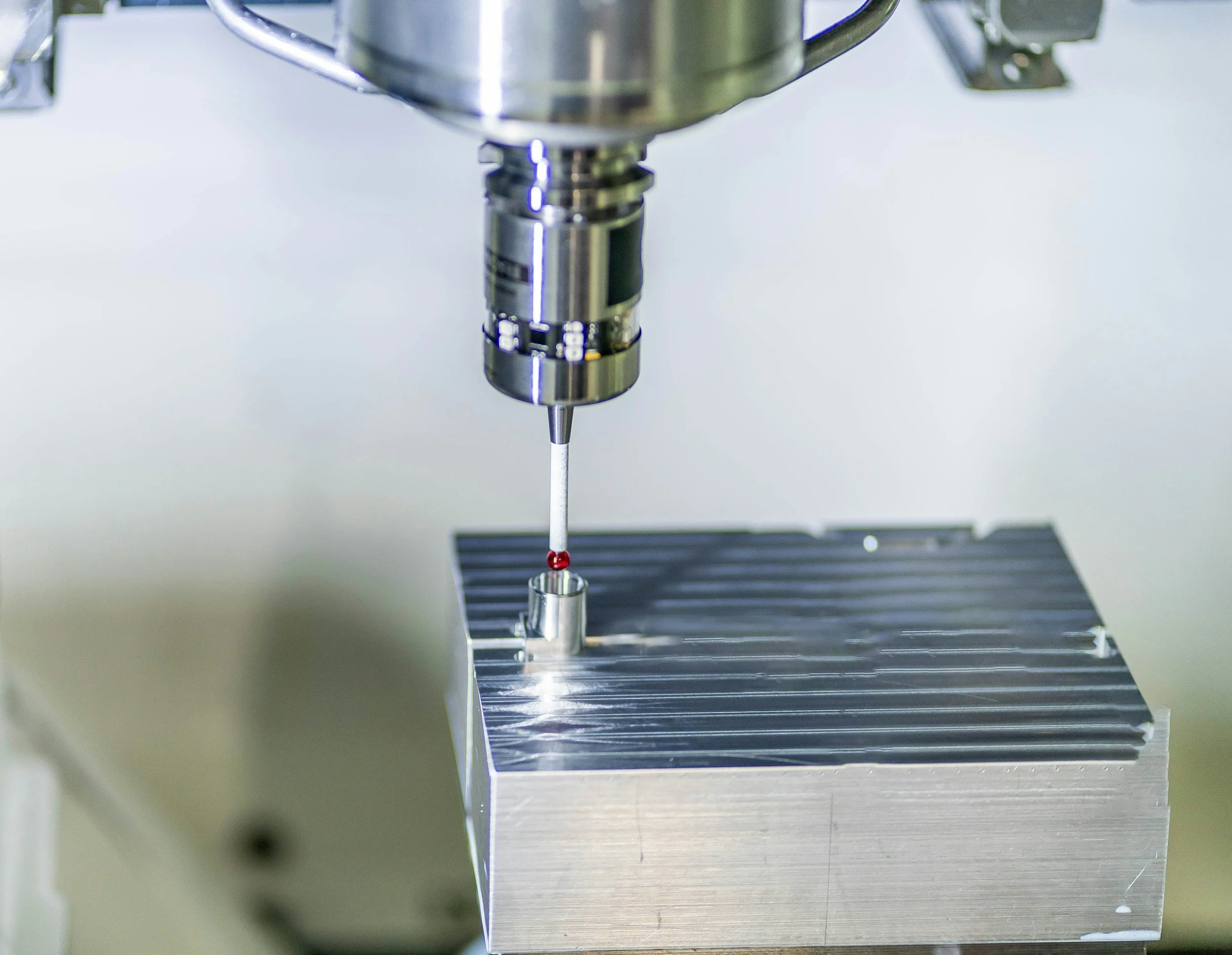 Spindle probe measuring a machined aluminum block on a CNC mill