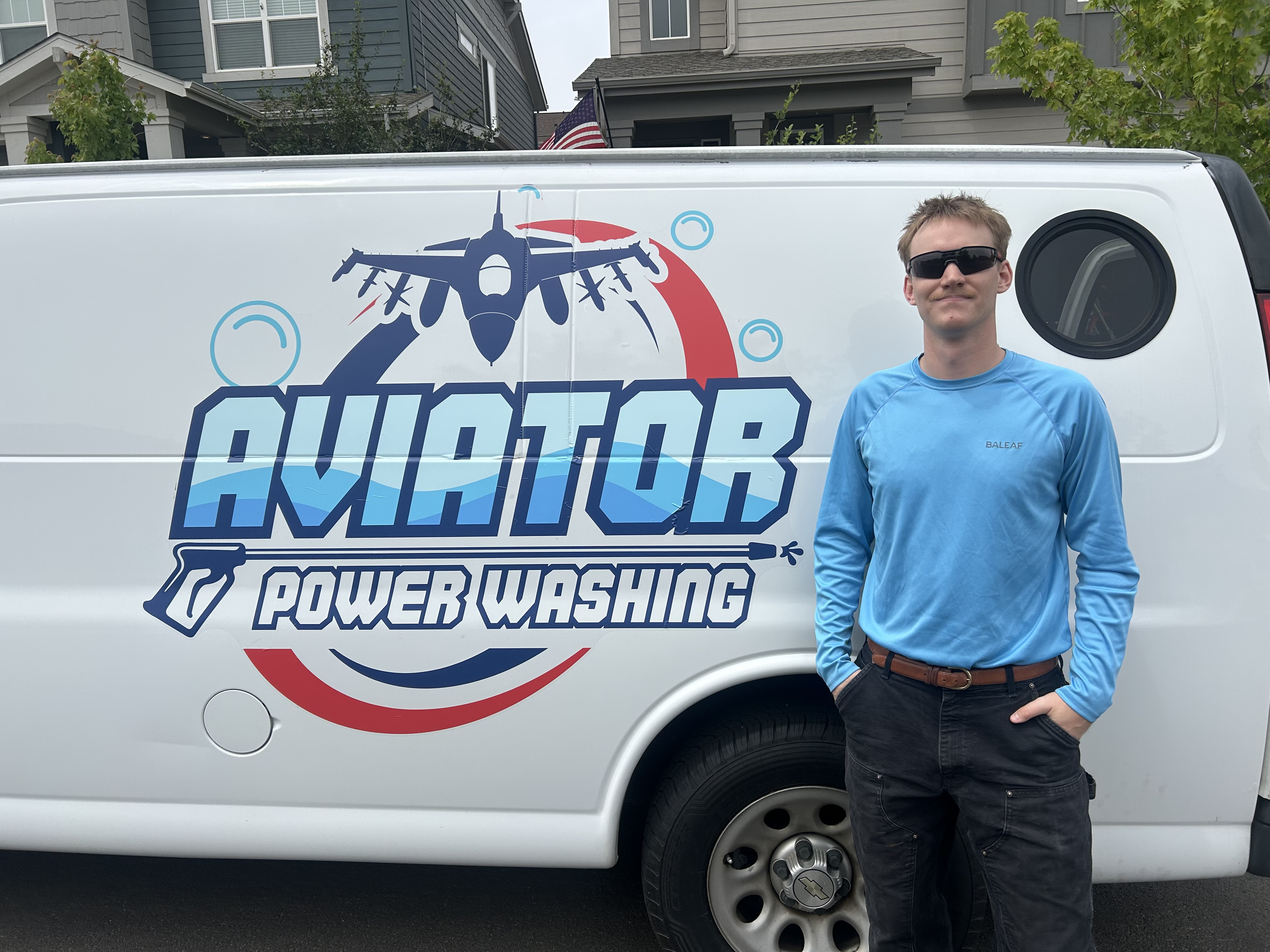 Owner of Aviator Power Washing standing proudly with the company service van offering professional exterior cleaning services.