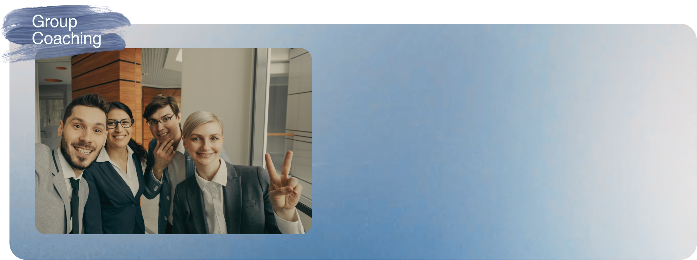 Four people smiling inside an office, with one person making a peace sign gesture.