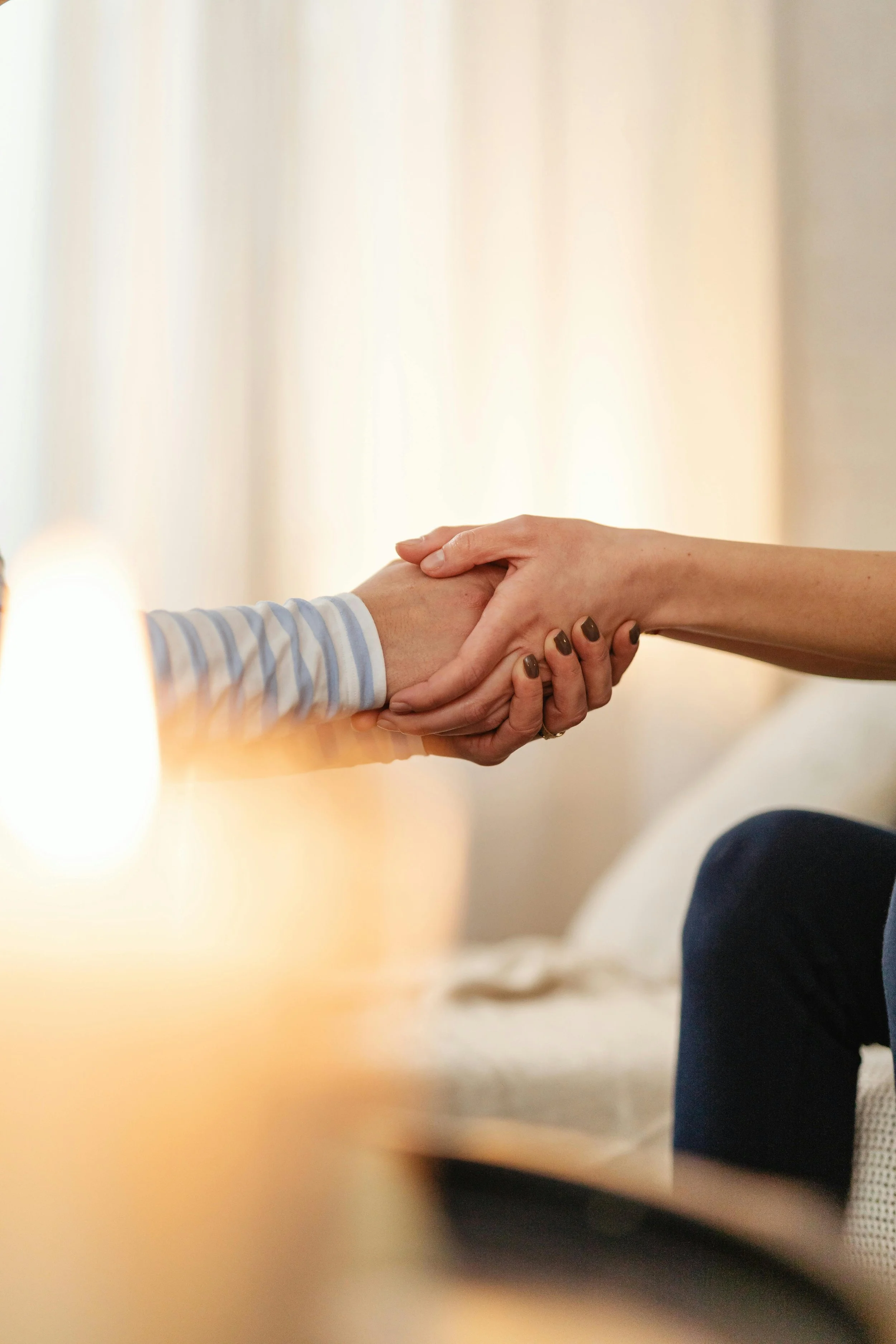 Two people shaking hands with a light-colored background.
