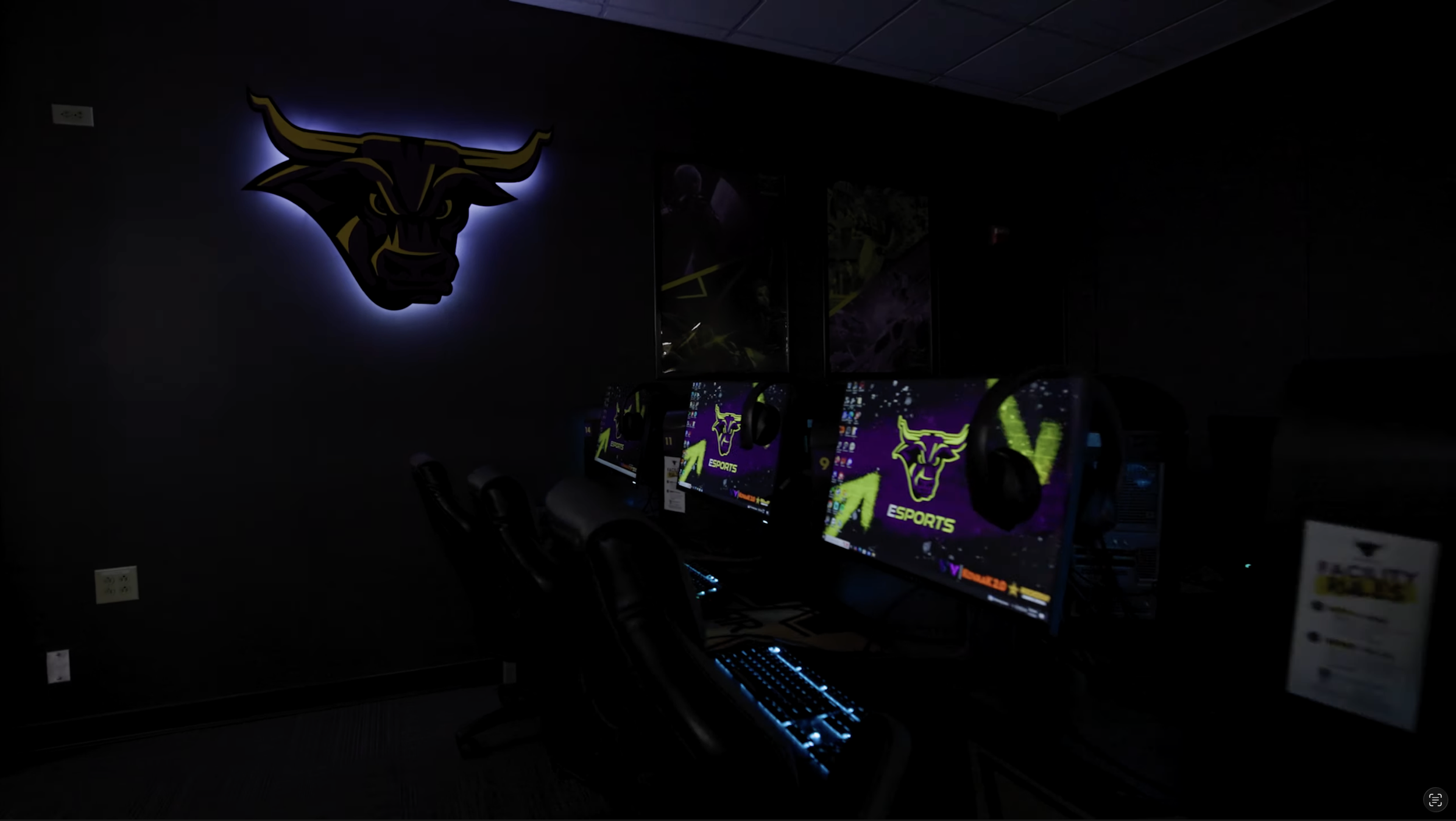 A video screen shot of Minnesota State University, Mankato Esports Facility Tour video featuring the Minnesota State University, Mankato Maverick Esports logo lit sign in the background with a row of gaming monitors, keyboard, and mice in front.