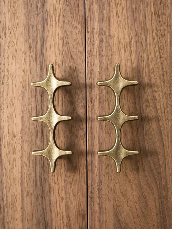 Two gold-colored metal hooks attached to a wooden surface.