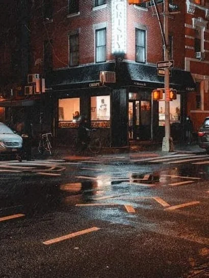 building lights reflecting in wet street