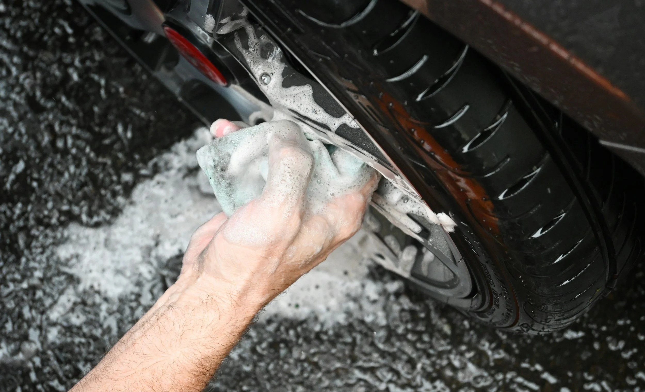 Hand washing a vehicle wheel during a premium mobile auto detailing service in Ocala, FL
