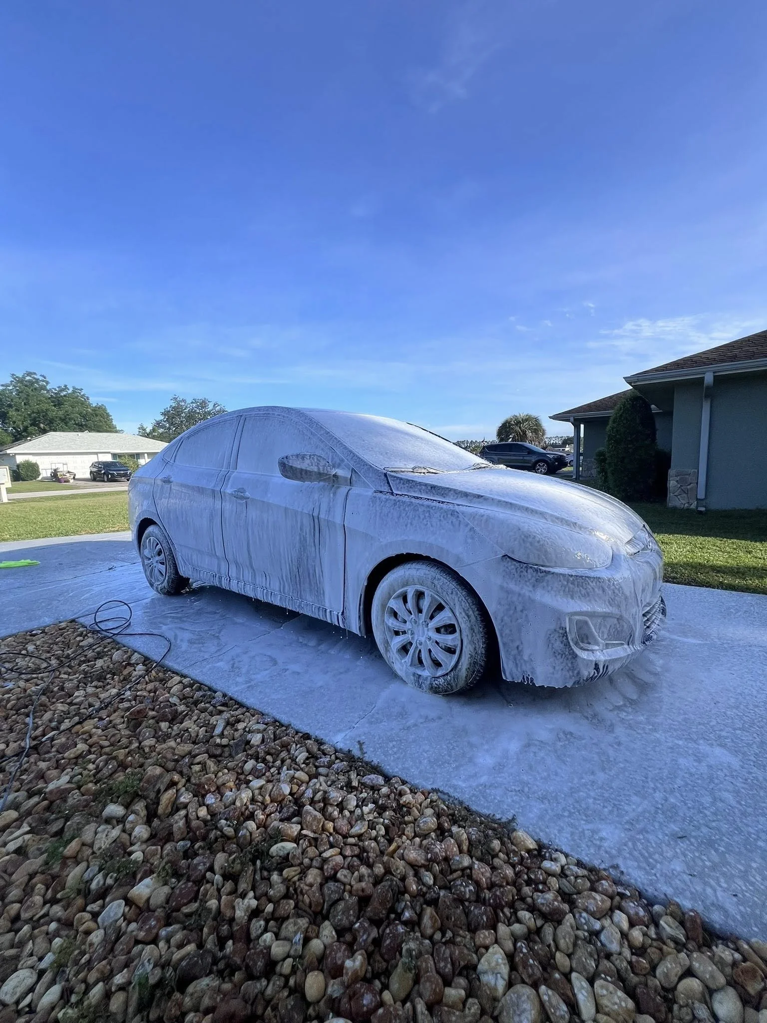 Luxury sedan covered in thick foam during a touchless pre-wash by a trusted mobile detailing company in Marion County, FL
