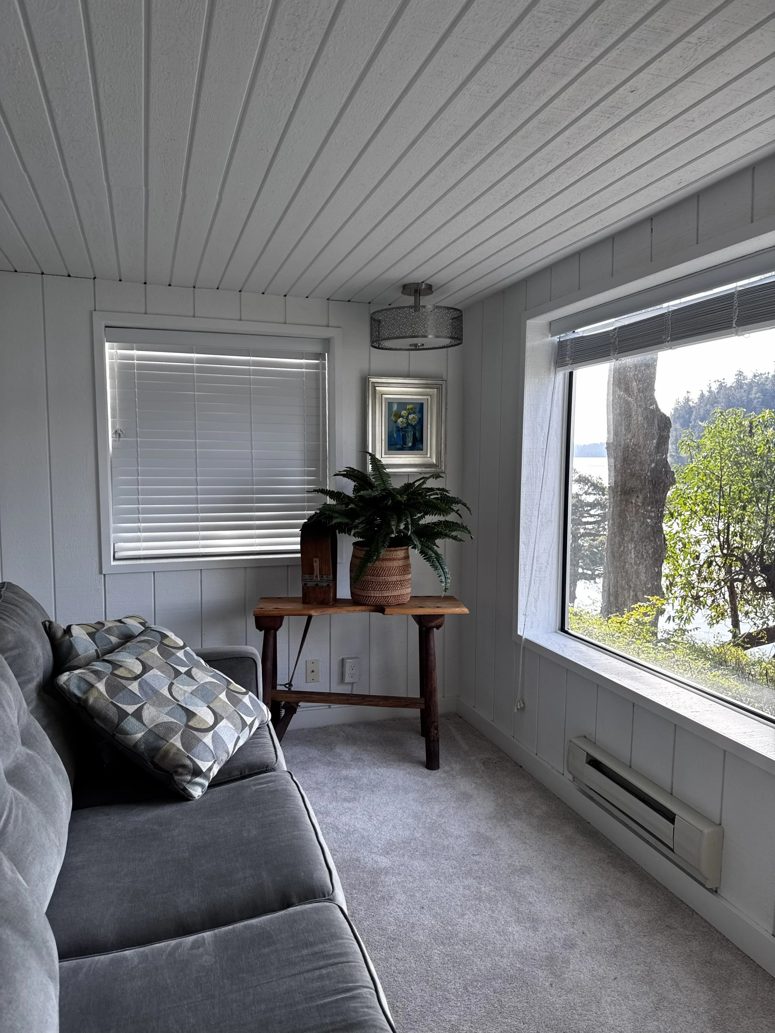 The sunroom is a great place to read and bird watch.  There is a door that opens to a deck and stairs down to the lawn and gardens. 