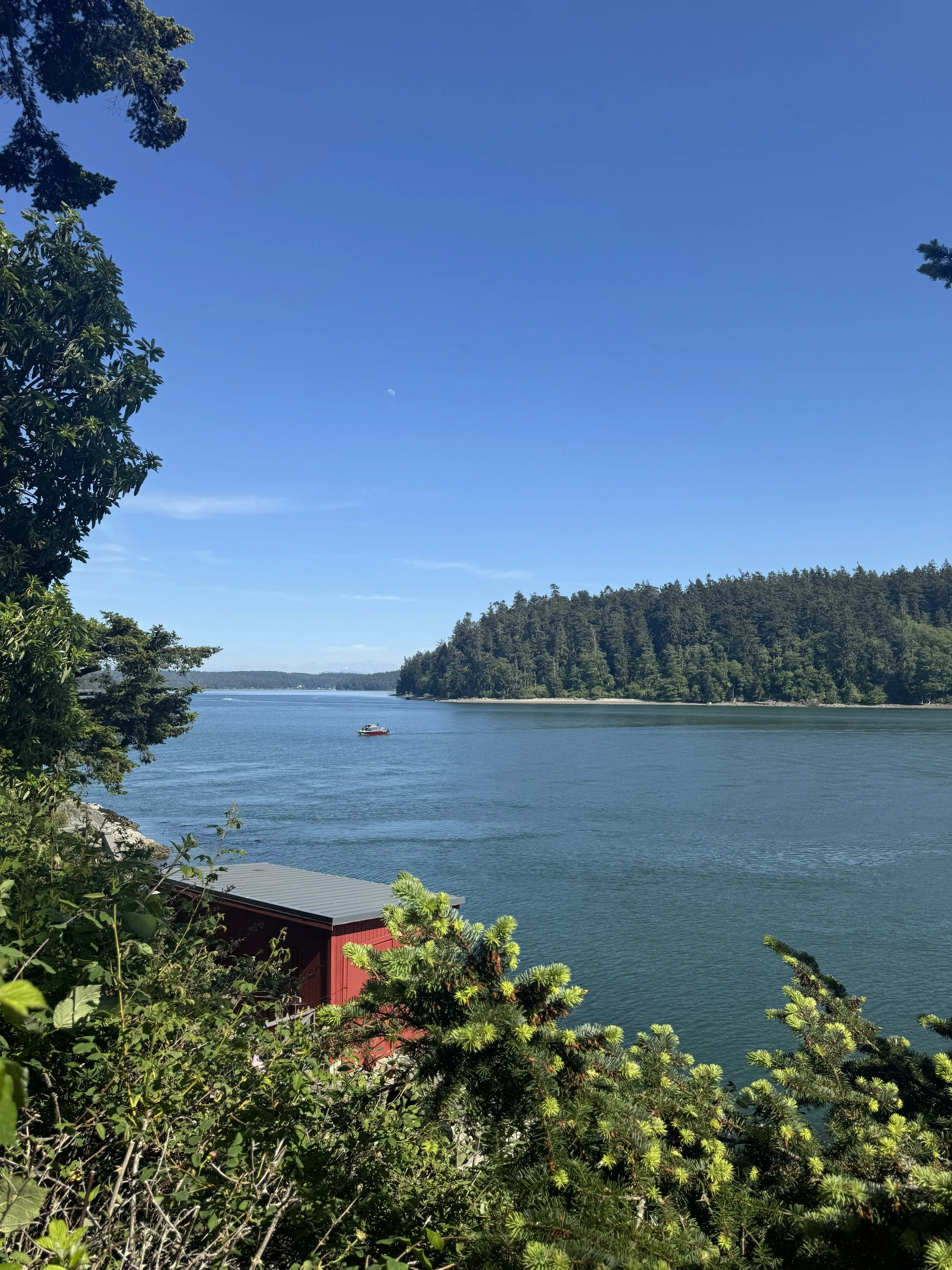 The boat house is painted a cheery red and is tucked into the bedrock along the waterfront.