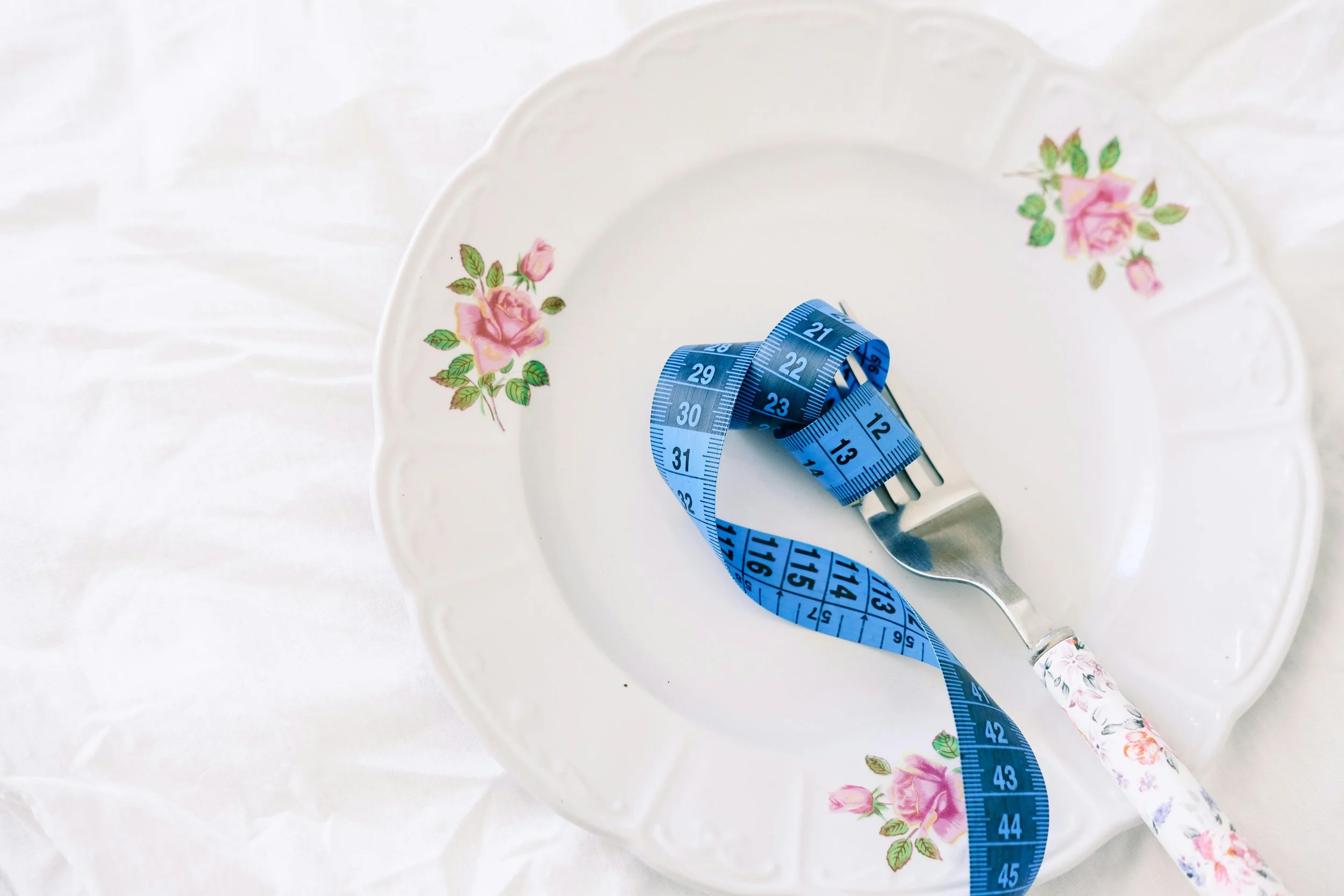 Floral plate with tape measure wrapped around fork