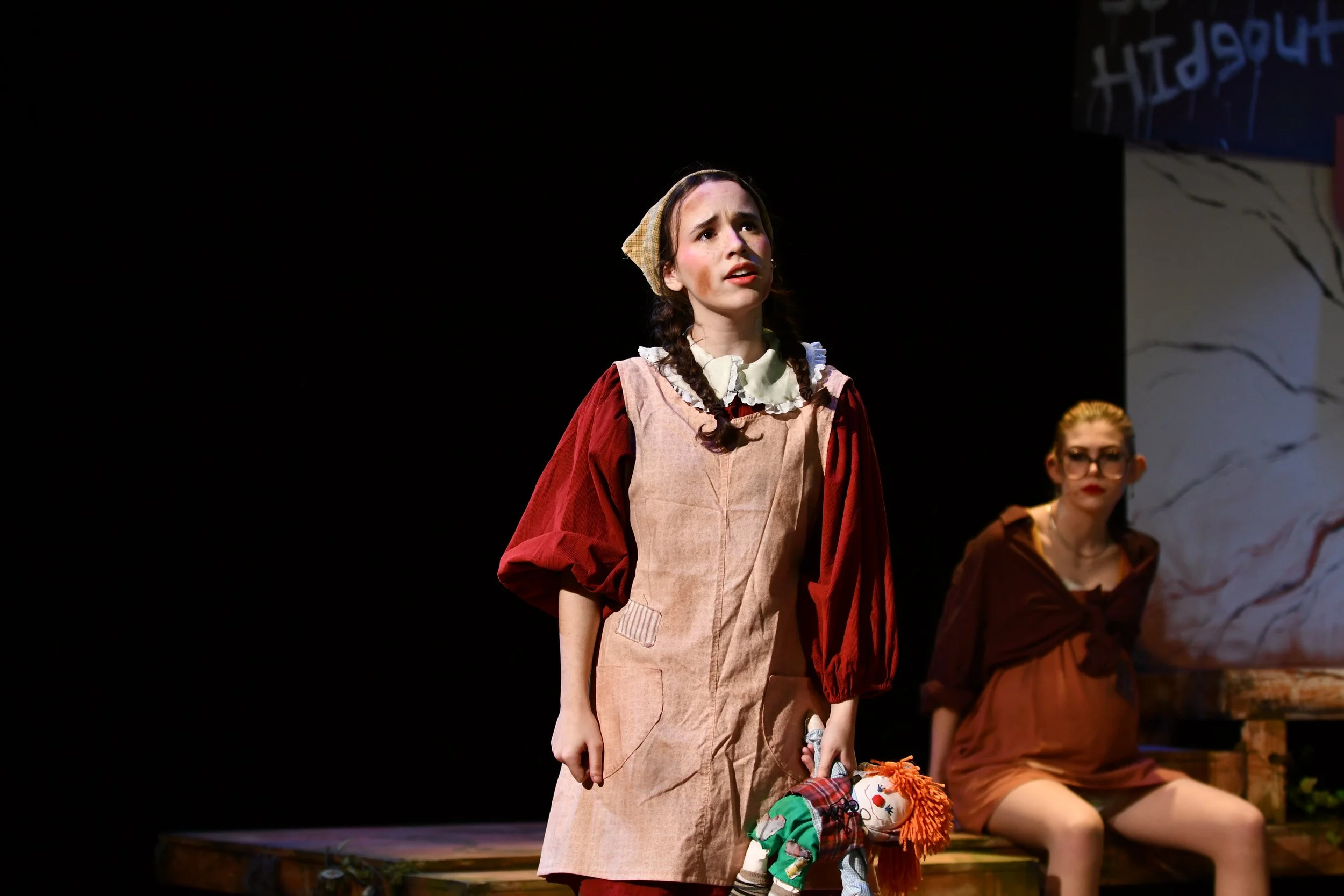 "Urinetown", Spring 2026. Directed by Claire D. Kolheim. Written by Greg Kotis. Photo: Ava Gabriel (center), Kara Lynn Noggle (back).