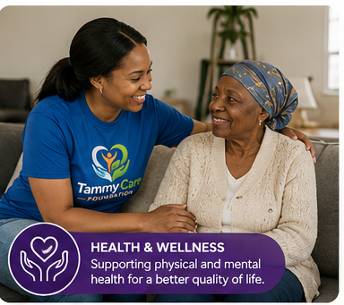 A young woman in a blue Tammy Carroll Foundation t-shirt supports an older woman smiling with a bandana on her head in a cozy room, promoting health and wellness for better quality of life.