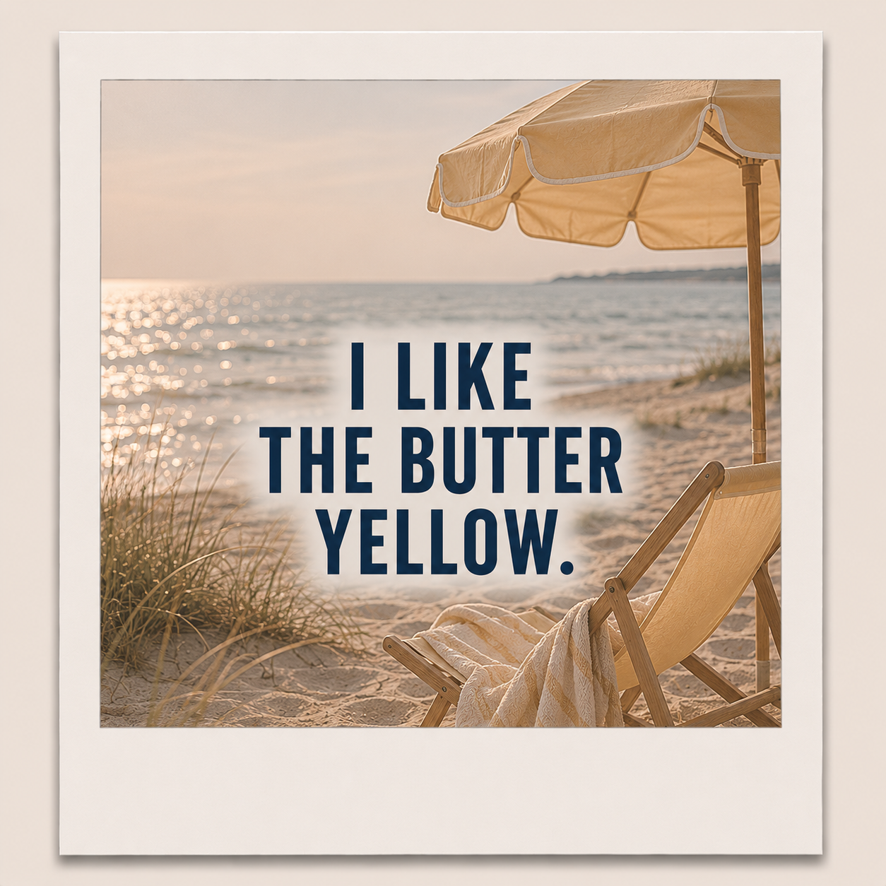 A beach scene with a sandy shore, grassy dunes, and a calm ocean under a setting sun. There is a beige lounge chair and a matching umbrella on the sand, with the ocean and sky in the background. Text over the image reads: "I LIKE THE BUTTER YELLOW."