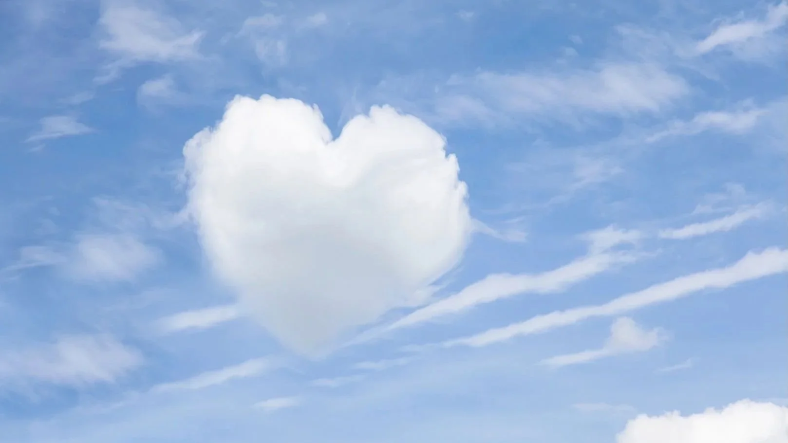 A blue sky with scattered white clouds, including a cloud shaped like a heart.