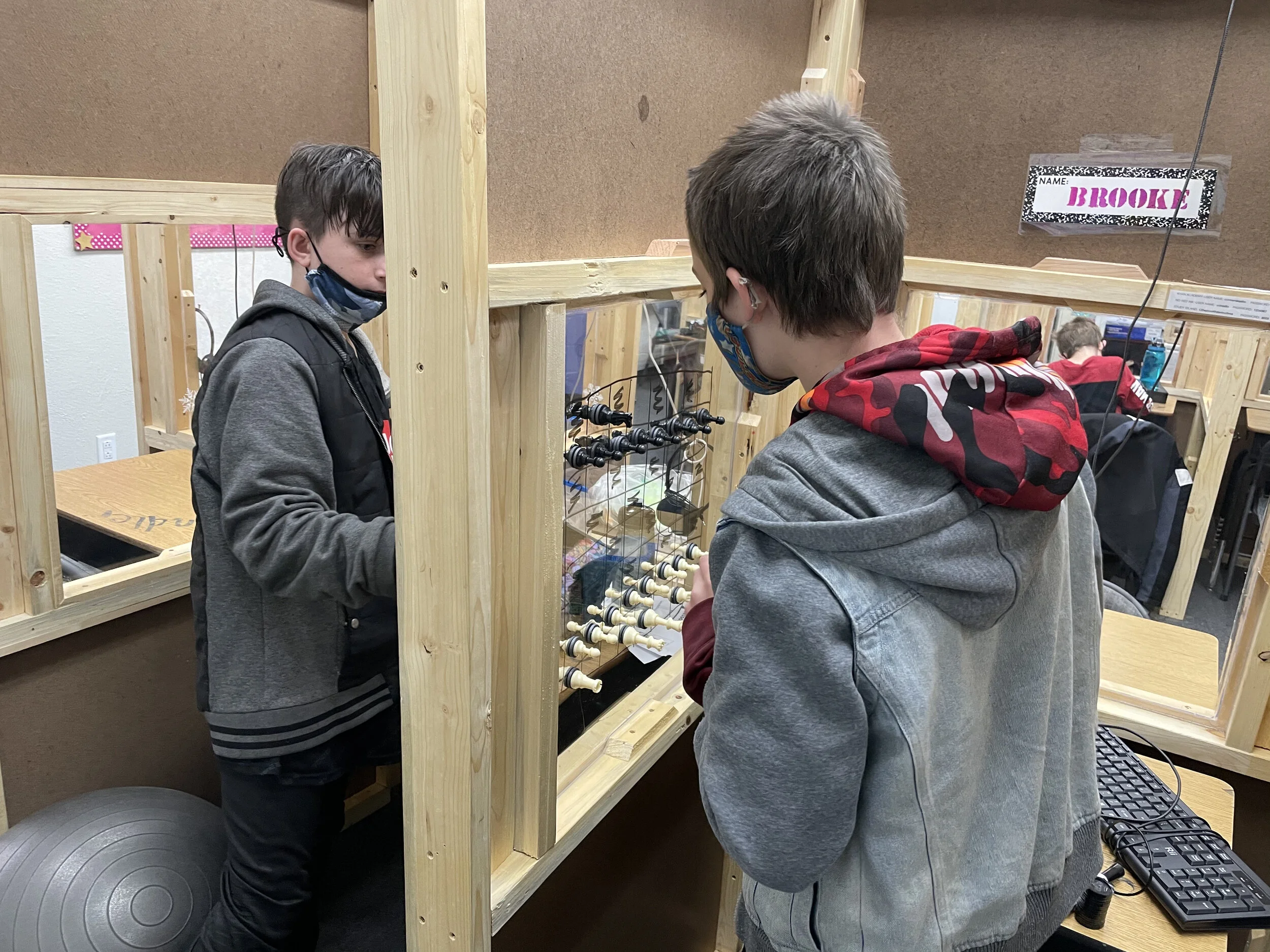 Students playing socially distanced chess during a break.