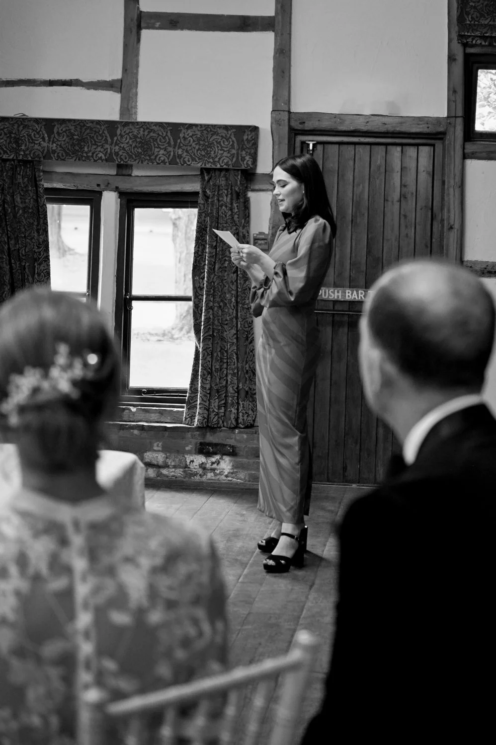Guest delivering a reading during an intimate barn wedding ceremony — candid documentary wedding photography by Tasha Boorman, Nottinghamshire wedding photographer