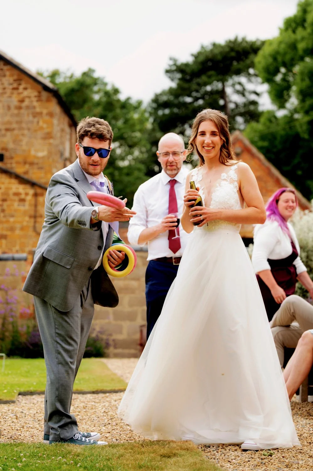 Bride and groom playing outdoor garden games with guests at The Courtyard Barns, Leicestershire — fun candid wedding reception photography by Tasha Boorman, Leicestershire wedding photographer