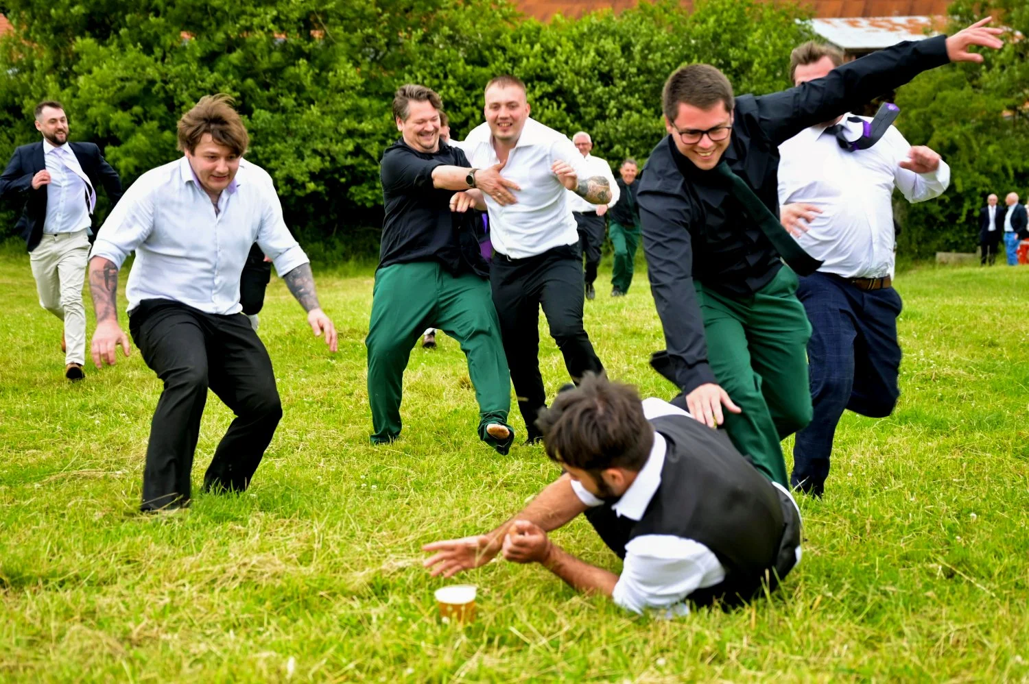 Groomsmen beer run game causing chaos and laughter at a Nottinghamshire wedding — fun candid wedding photography by Tasha Boorman, Nottinghamshire wedding photographer