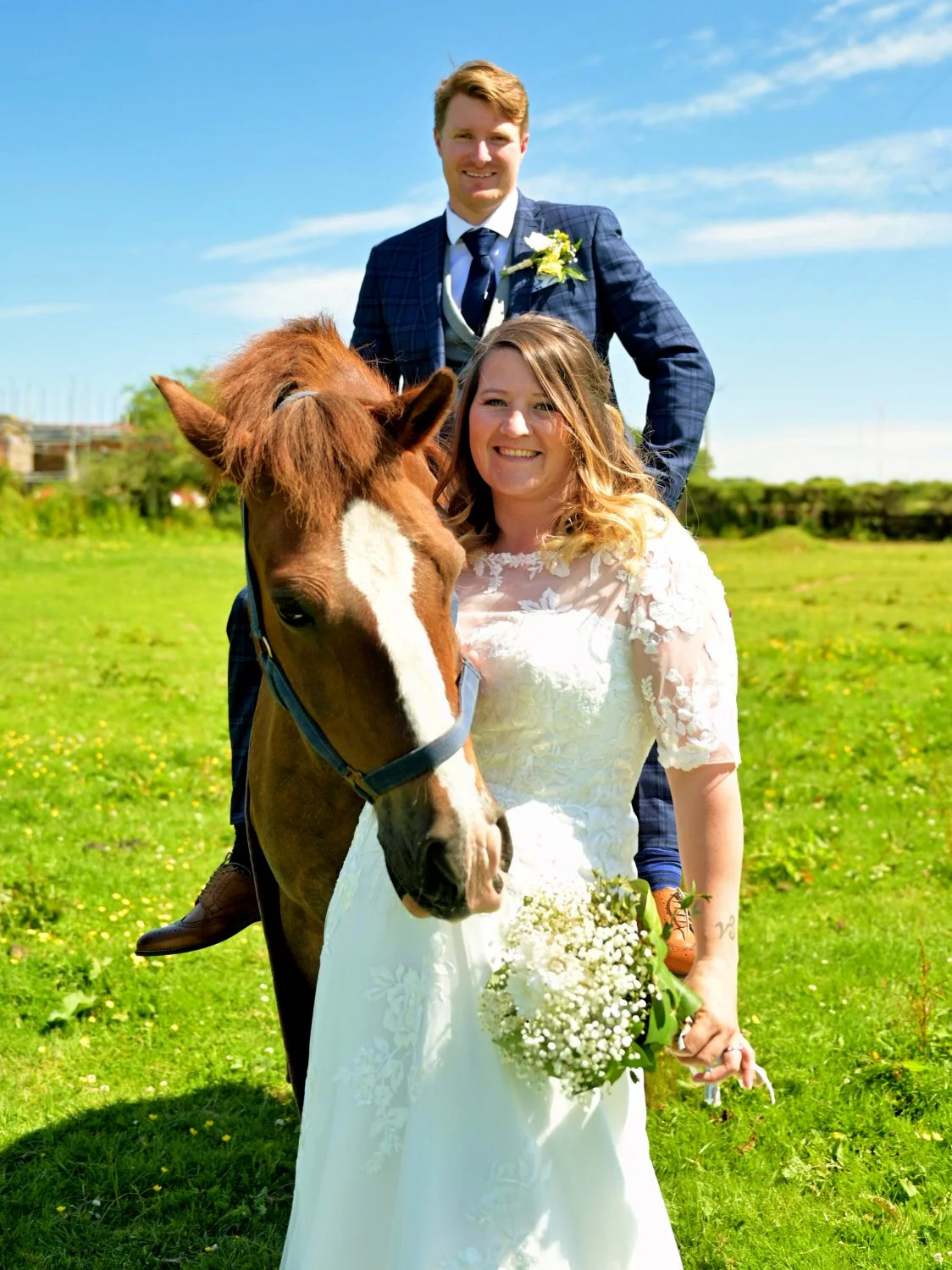 Bride and groom outdoor wedding portrait with chestnut horse, sunny field, fun relaxed farm wedding photography Hampshire