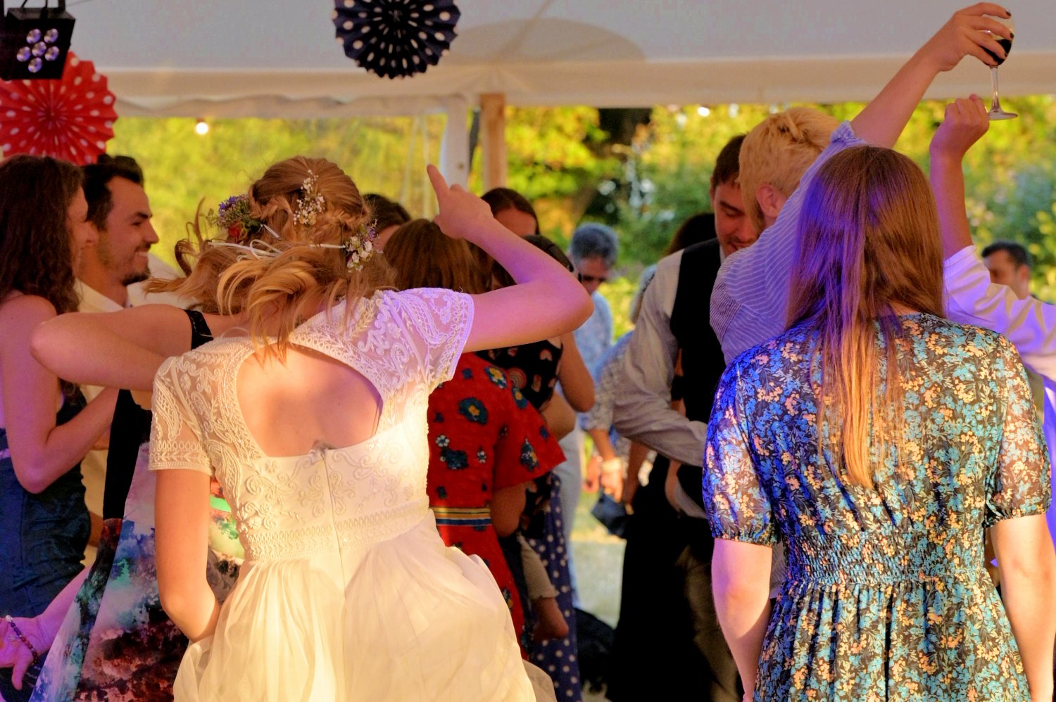 Bride and wedding guests dancing the evening away in a marquee at a festival style wedding — candid wedding photography by Tasha Boorman, Nottinghamshire wedding photographer