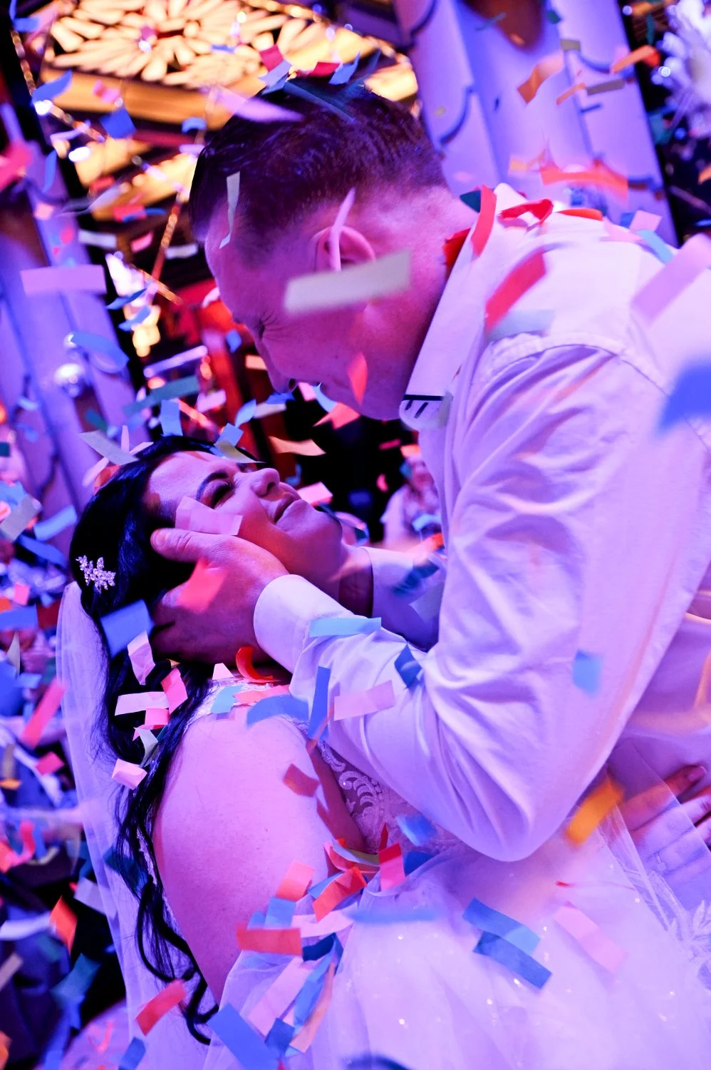 Romantic first dance confetti cannon drop at The Earl of Doncaster — bride and groom surrounded by colourful confetti under purple lights — creative wedding photography by Tasha Boorman, Doncaster wedding photographer