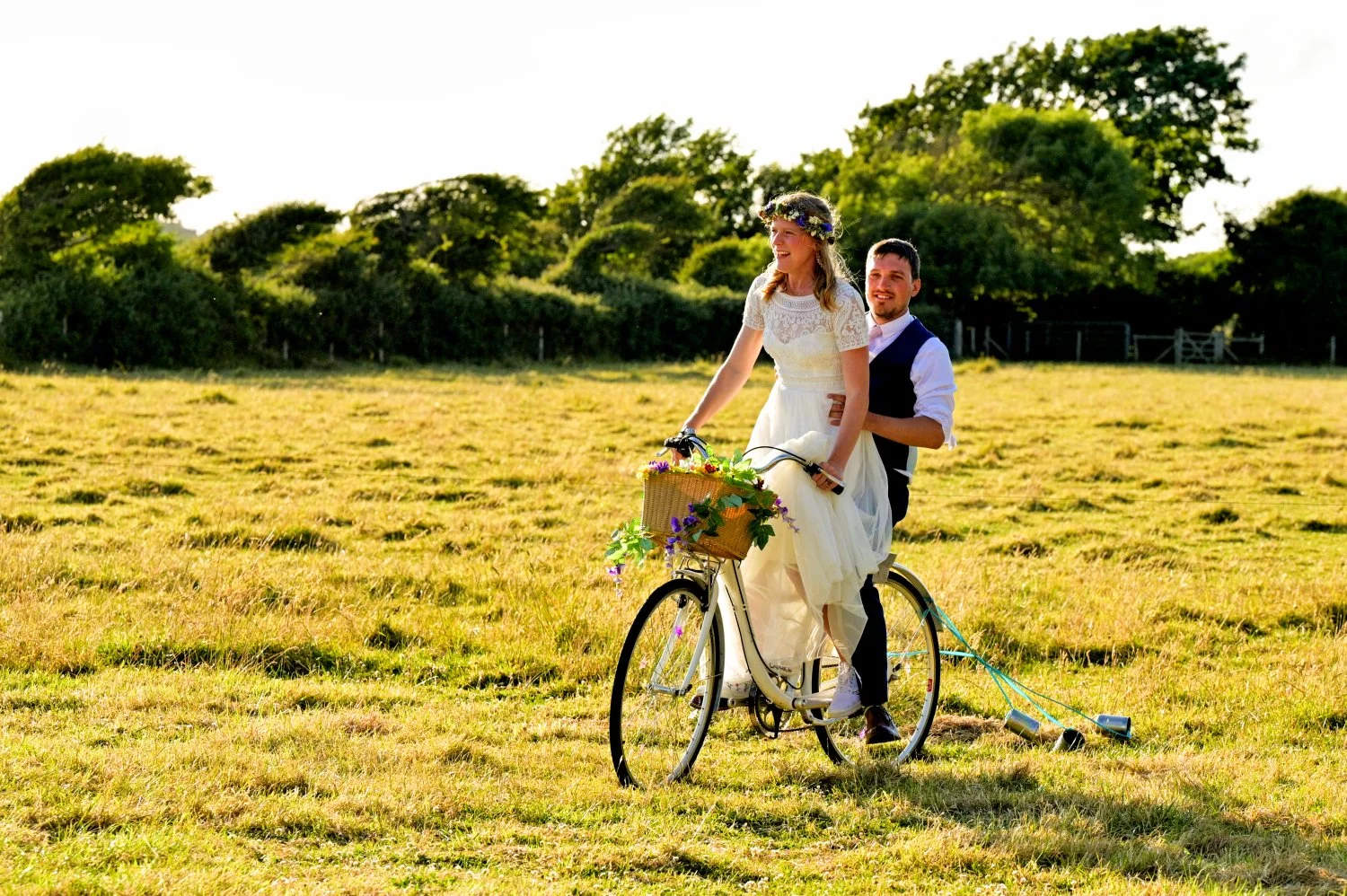 ride and groom cycling together through golden hour fields incorporating their love of bike riding — personalised wedding photography by Tasha Boorman, Nottinghamshire wedding photographer