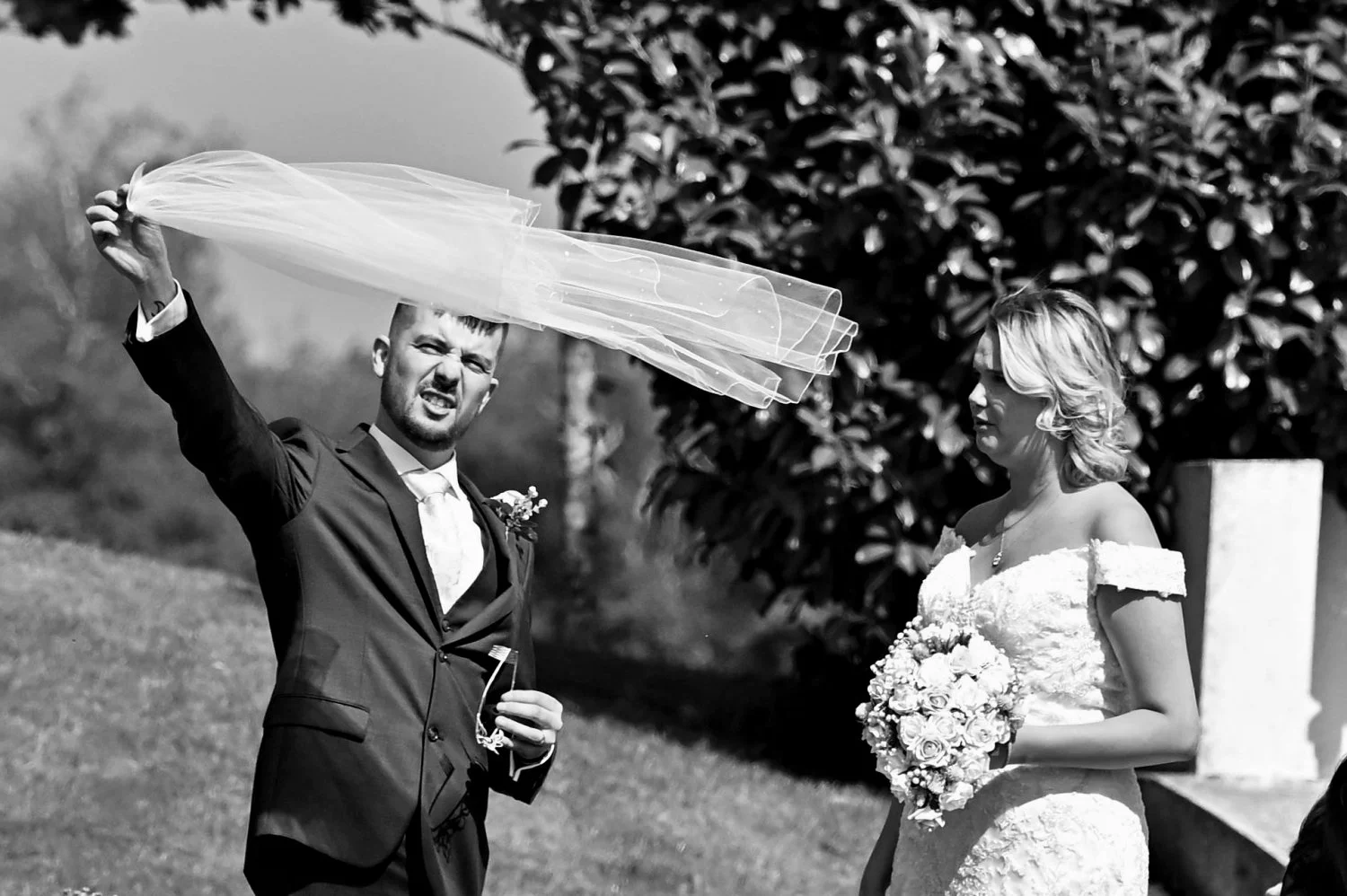 Hilarious candid moment as groom battles with bride's veil in the wind on their wedding day — fun documentary wedding photography by Tasha Boorman, Nottinghamshire wedding photographer