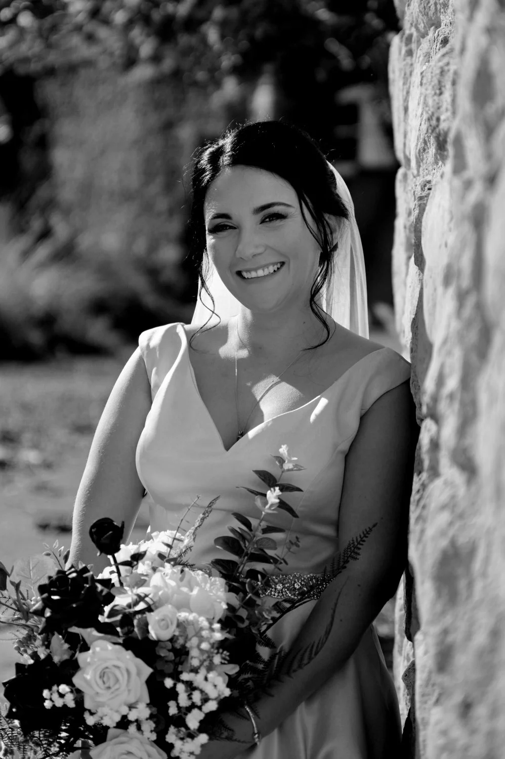 Beautiful natural light bridal portrait leaning against a stone wall — wedding photography by Tasha Boorman, Nottinghamshire wedding photographer