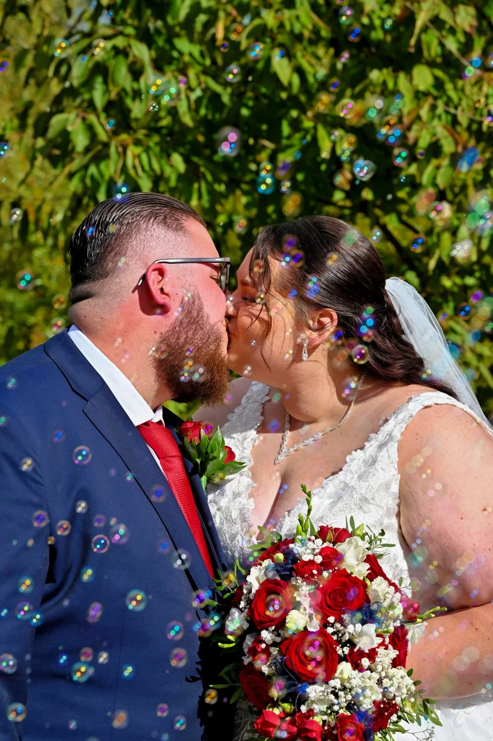 Bride and groom sharing their first kiss surrounded by beautiful soap bubbles instead of confetti — creative wedding photography by Tasha Boorman, Nottinghamshire wedding photographer