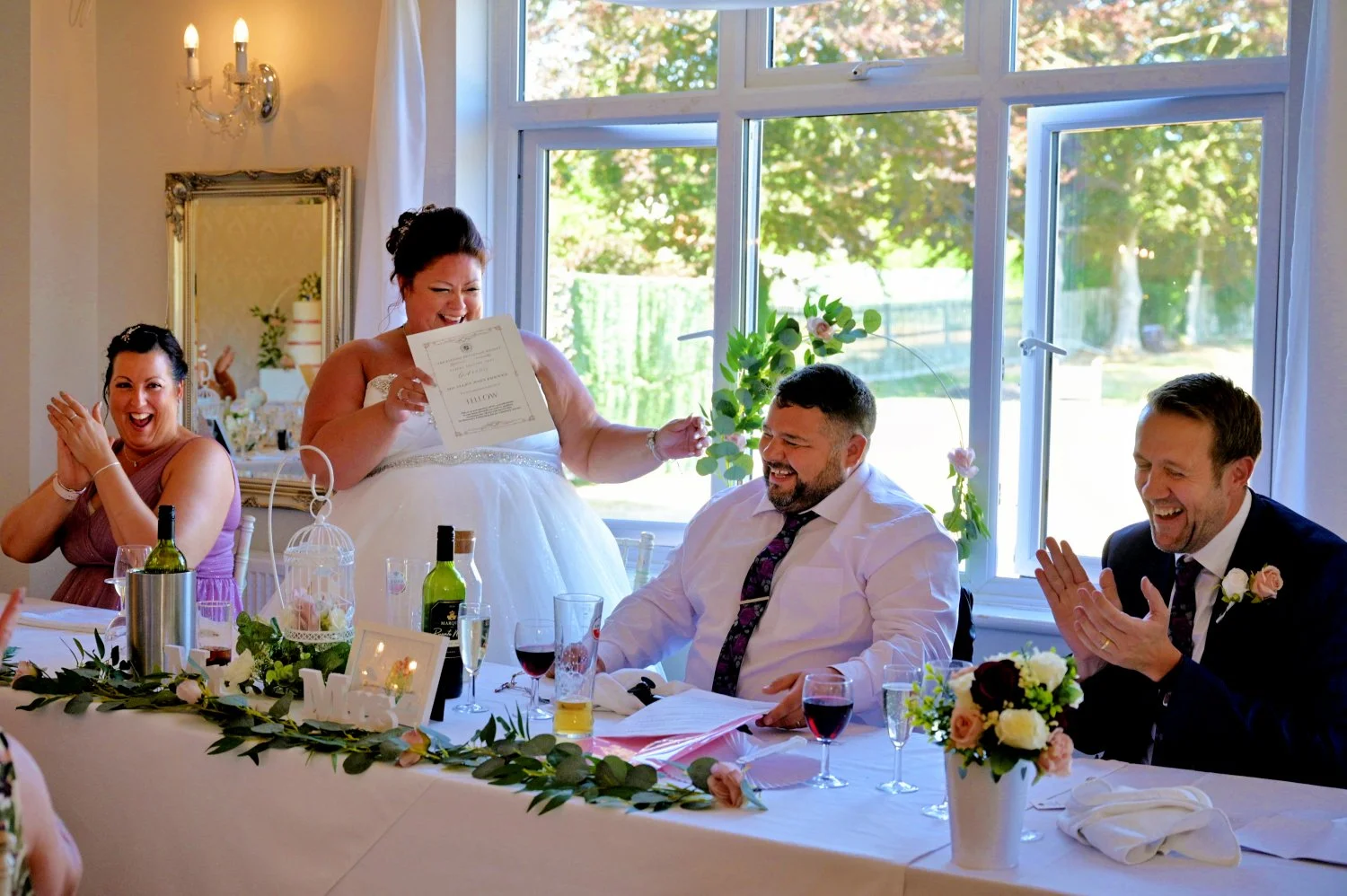 Bride surprising groom with a hilarious elite club certificate during wedding speeches — candid documentary wedding photography by Tasha Boorman, Nottinghamshire