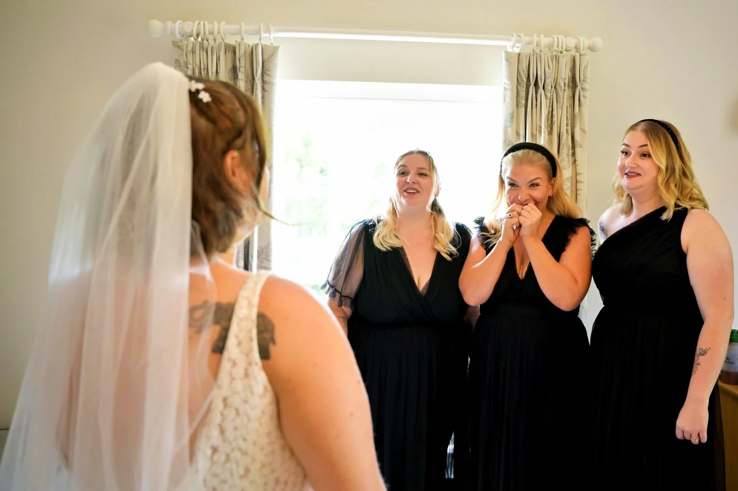 Emotional bride reveal moment as bridesmaids see her in her wedding dress for the first time — candid documentary wedding photography by Tasha Boorman, Nottinghamshire wedding photographer
