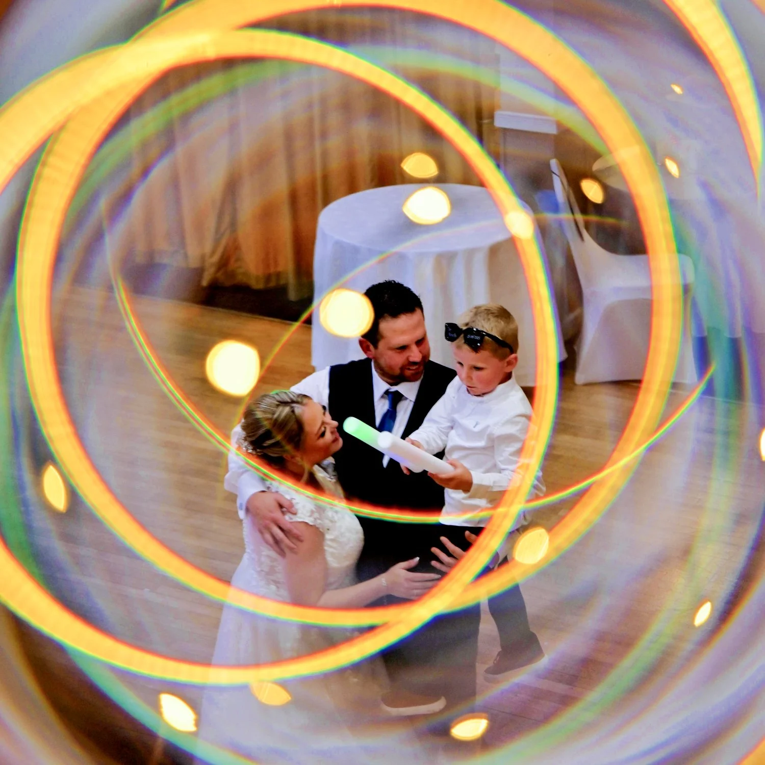Bride, groom and young guest captured inside a stunning light painted swirl using creative long exposure techniques — artistic wedding photography by Tasha Boorman, Nottinghamshire wedding photographer
