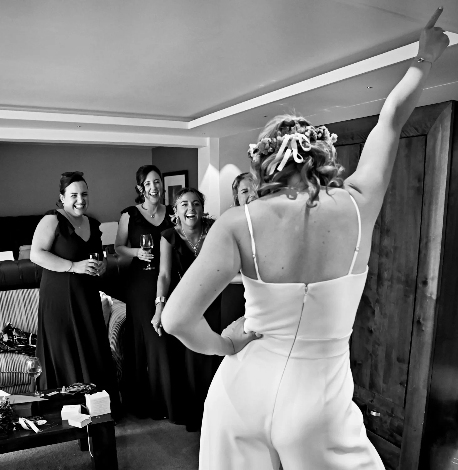 Bride dancing and celebrating in her wedding dress for her hysterical bridesmaids during wedding morning preparations — candid getting ready photography by Tasha Boorman, Nottinghamshire wedding photographer