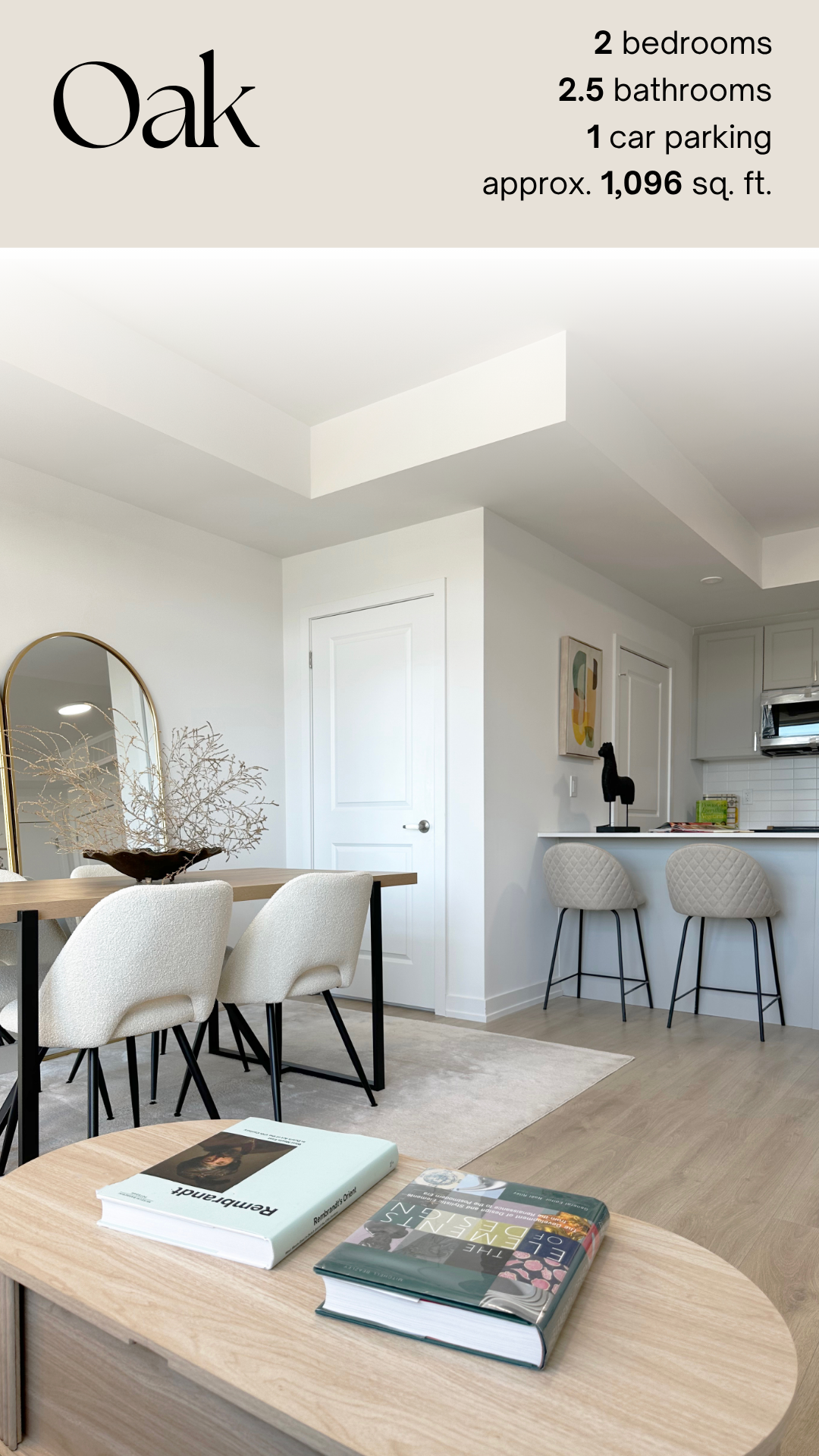 Modern kitchen and dining area with white walls, beige chairs, a wooden table, decorative mirror, books, and minimalistic decor.