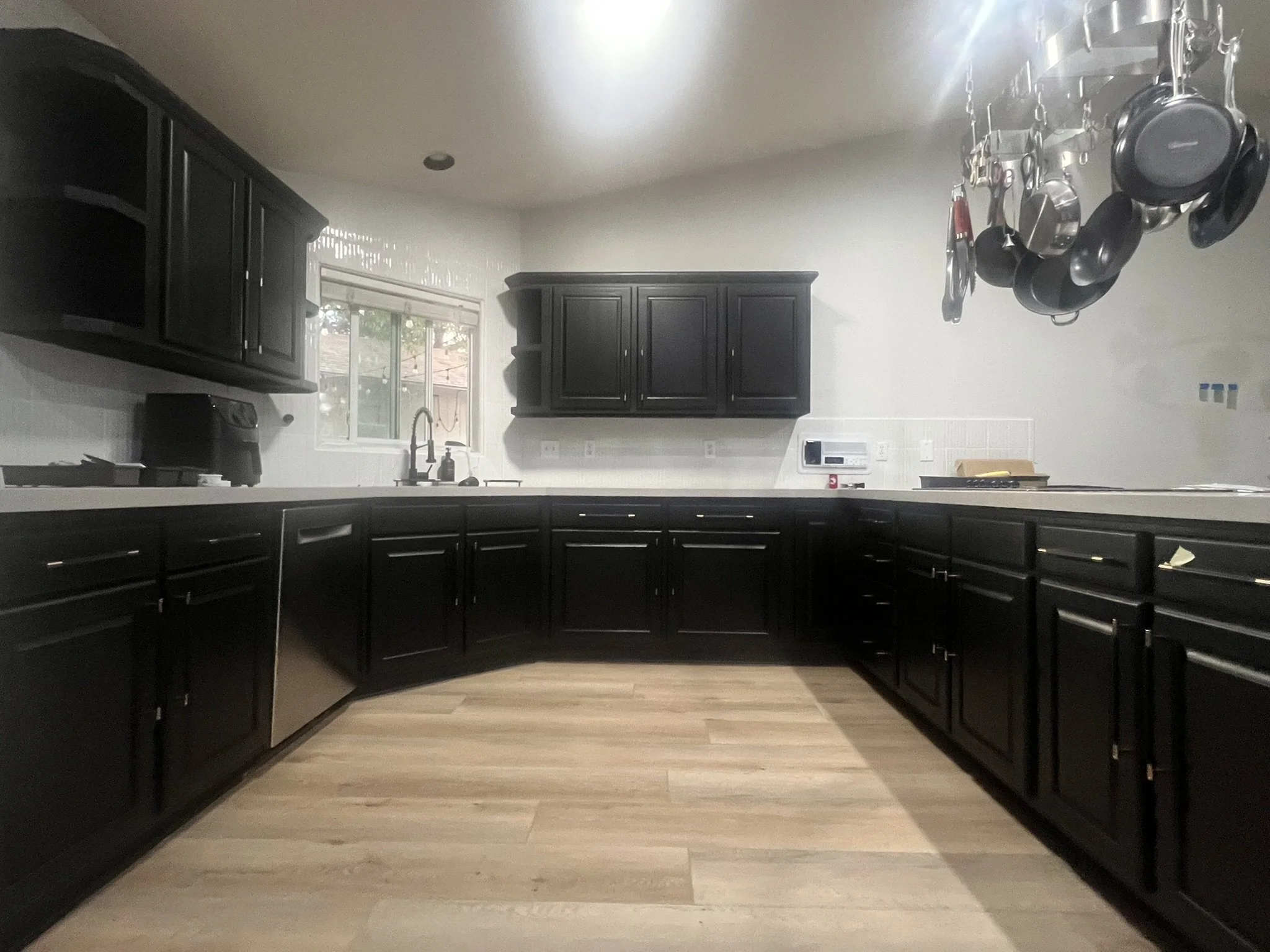 #L   After-    Kitchen cabinets that got refinished with a beautiful black design.