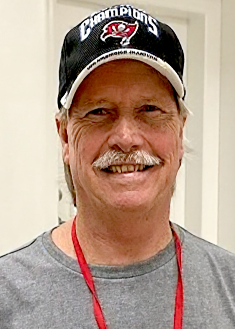 Smiling man wearing a San Francisco Giants Champions baseball cap and gray shirt