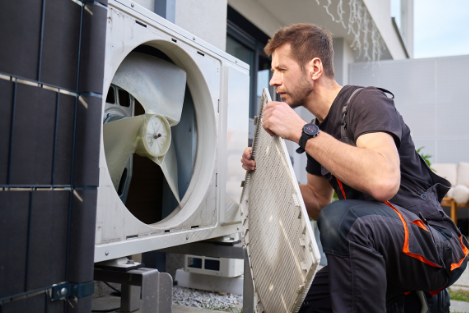 Man inspecting the inside of a washing machine outside