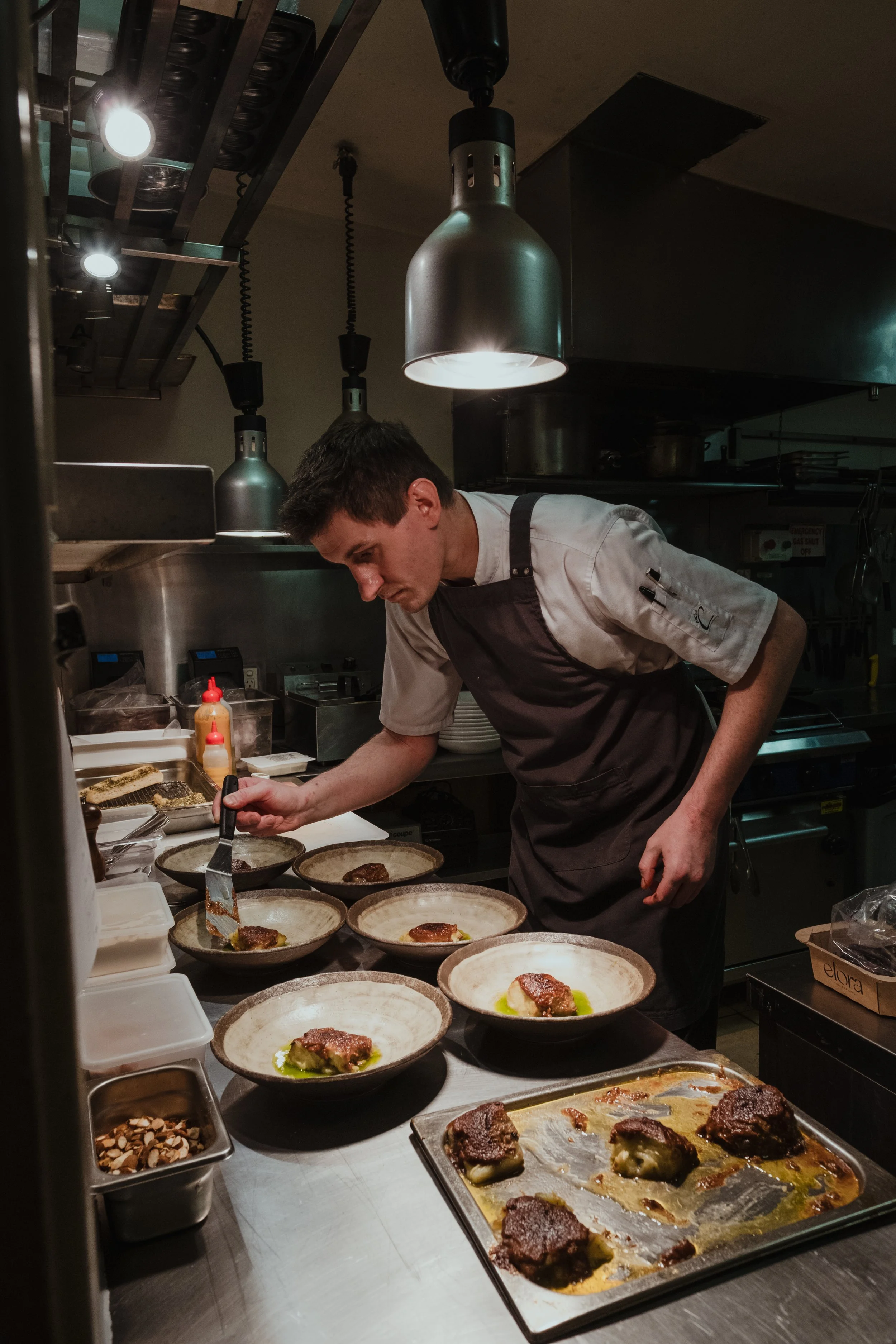 Chef Alex Fee plating dishes on the pass in the Pethers kitchen
