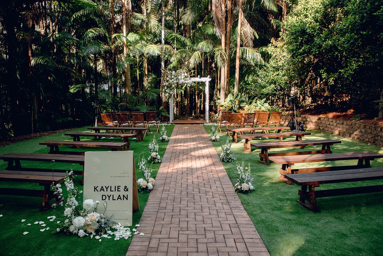 Ceremony aisle lined with florals leading to the wedding arbour
