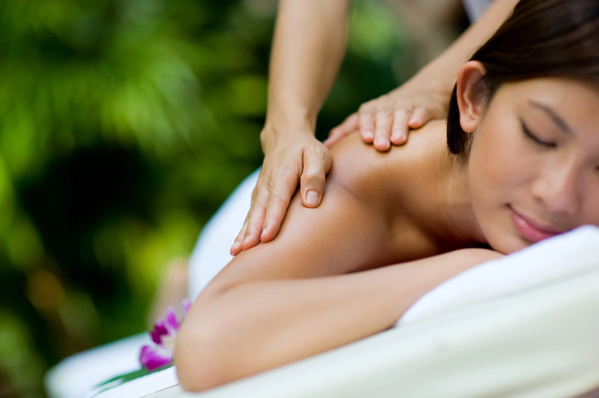 Guest receiving a shoulder massage on a treatment table