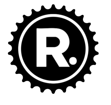 A black and white logo featuring a large letter 'R' inside a circle, surrounded by a scalloped border.