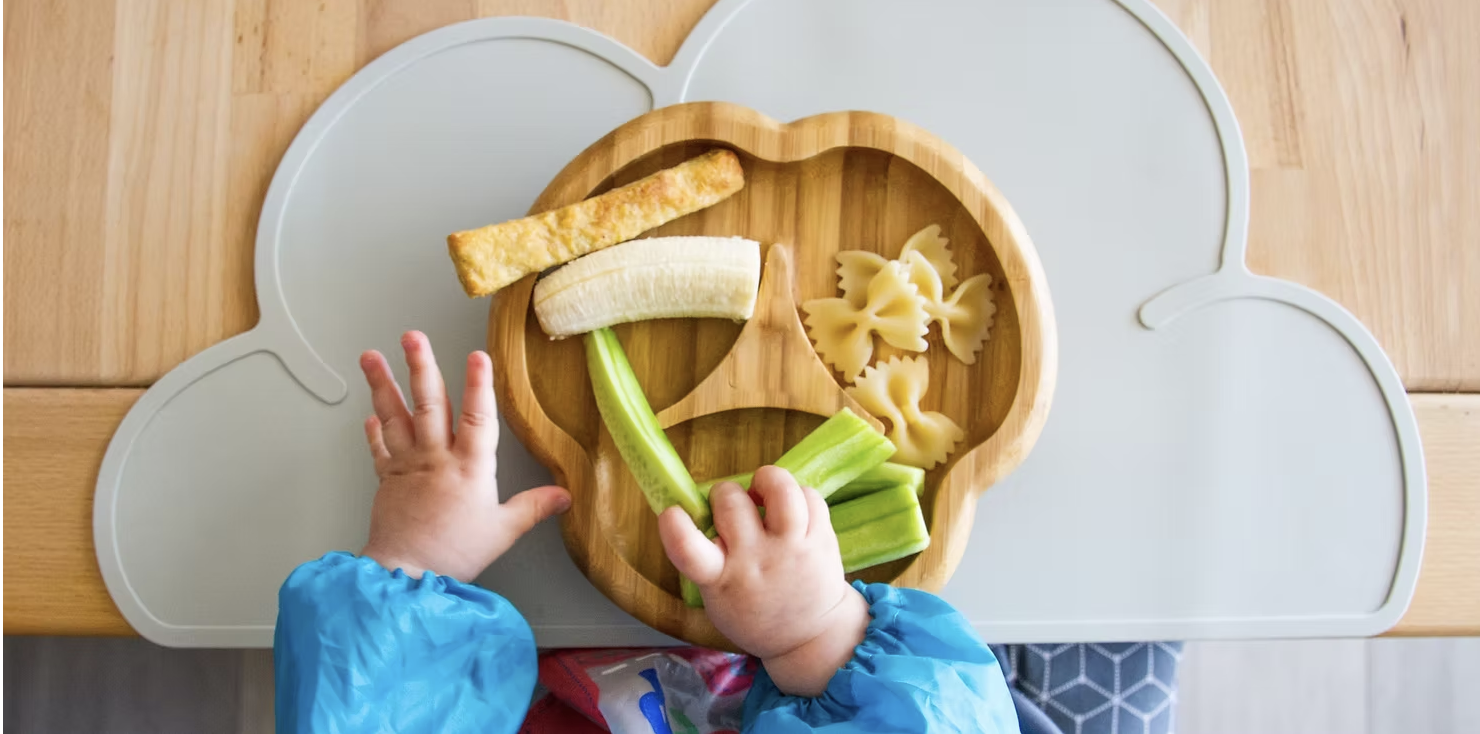 Toddler eating fruit, pasta and salad