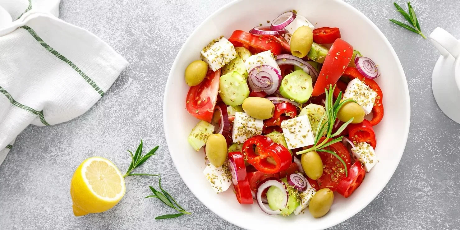 Greek Salad in a large bowl with lemon