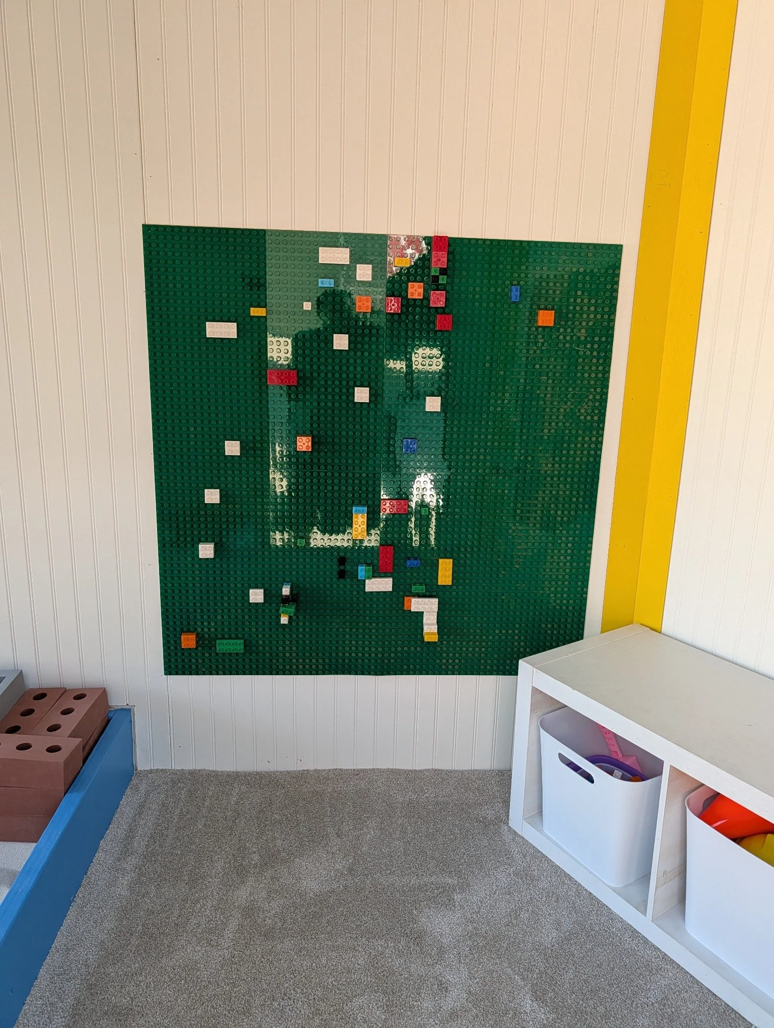 Green building-brick wall inside The Colorado Sandbox trailer