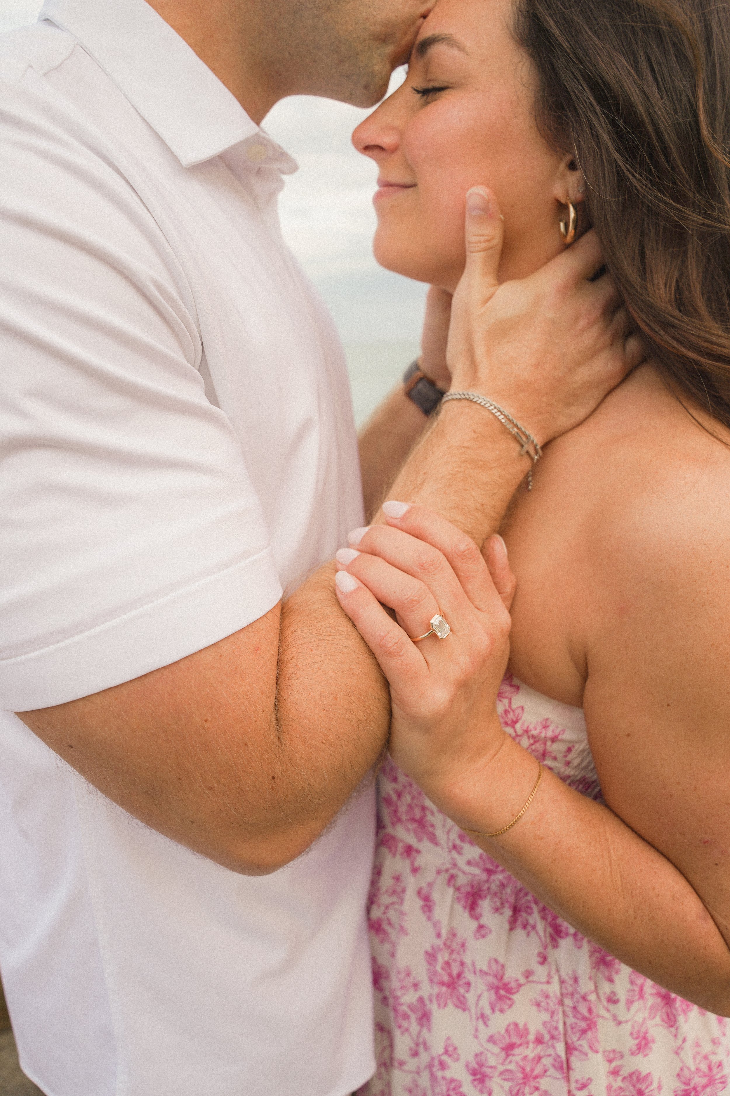 Honey+Haze Photography. A man and woman sharing an intimate moment, touching foreheads and holding each other, with the woman's eyes closed and soft smiles.