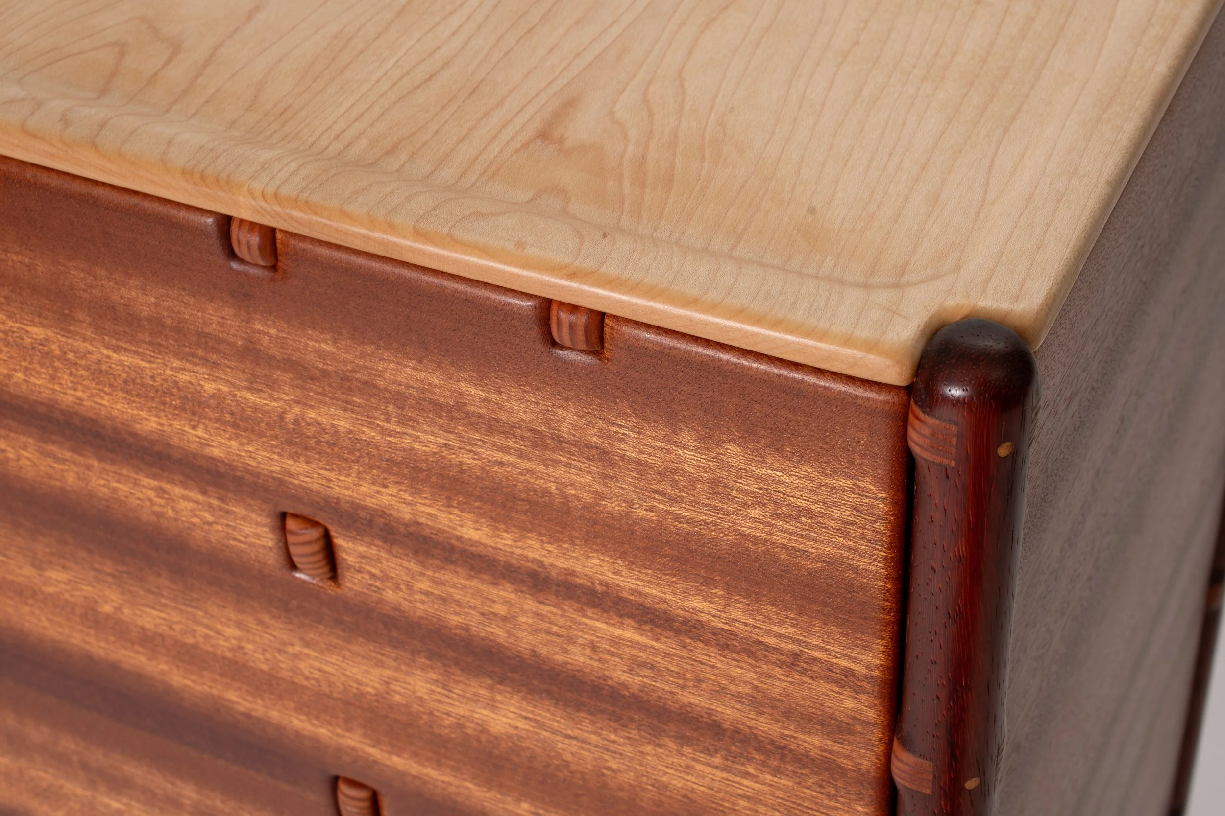 The structural elements protrude through the sapele panels, emphasizing the construction techniques.