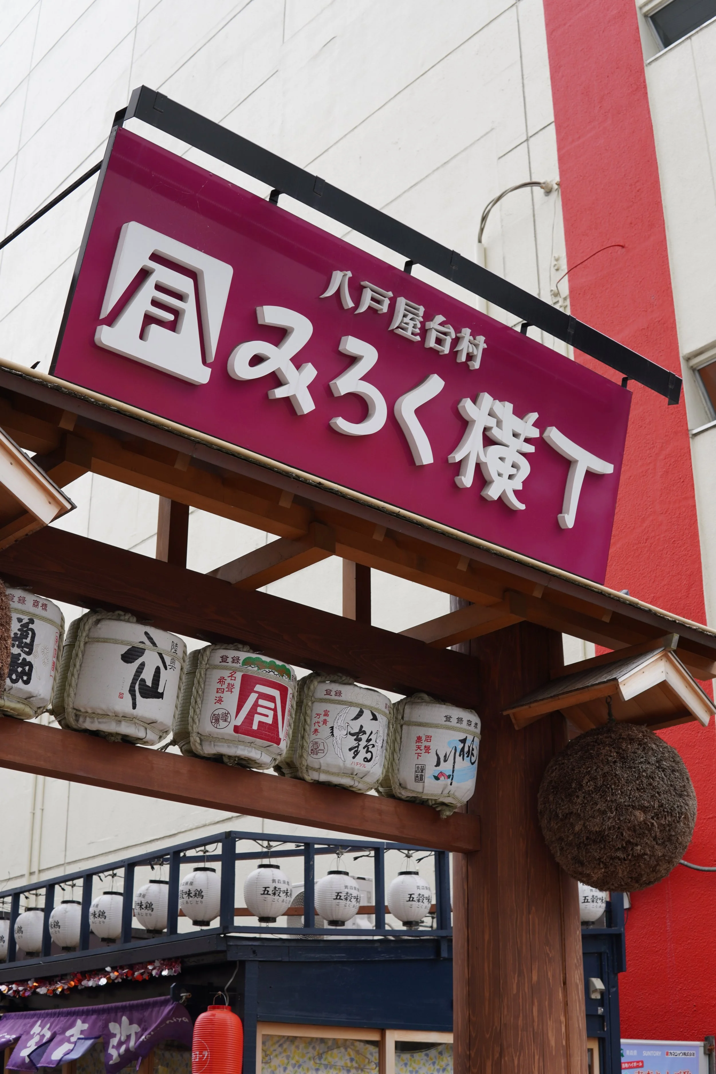 屋外に設置された看板と行灯、提灯の写真。温かみのある雰囲気で、日本の伝統的な装飾が見られる。