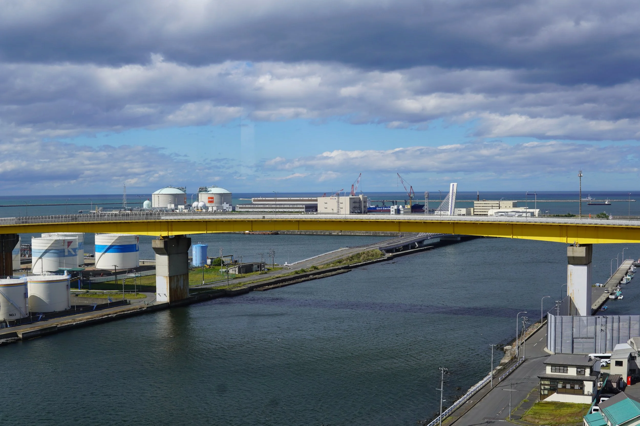 工場と油槽や橋と海の景色。曇り空の日の風景。