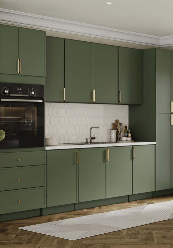 Green kitchen cabinets with gold handles, white hexagon tile backsplash, and a white countertop with kitchen items near the sink.