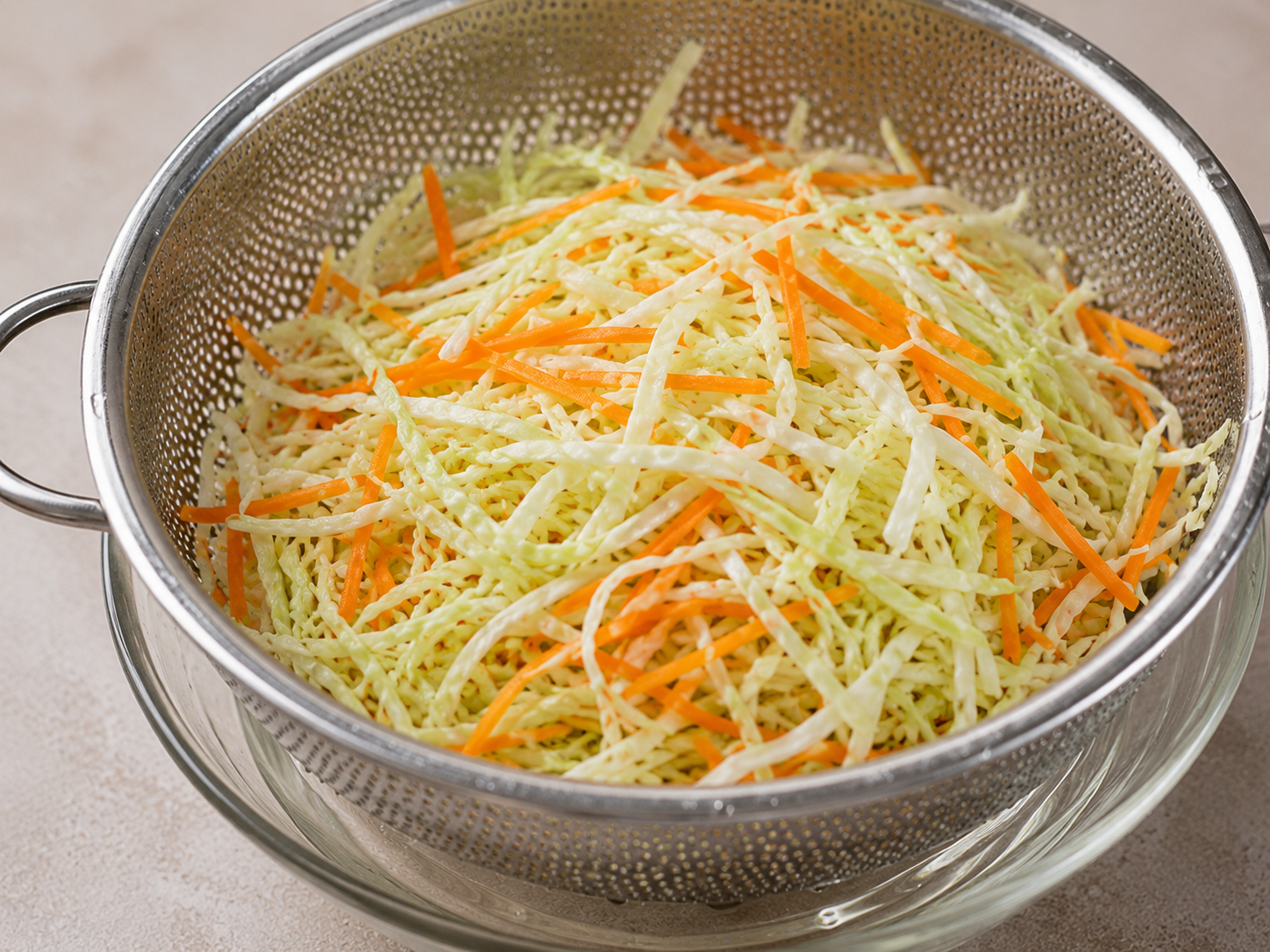 Shredded cabbage and carrot being chilled, drained, and dried for gỏi gà bắp cải.