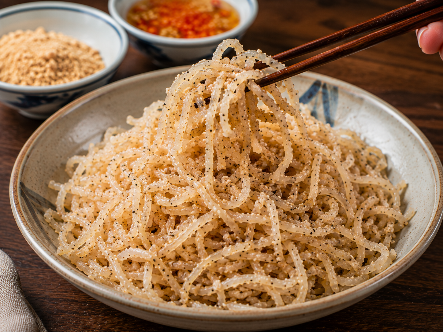 Shredded pork skin for Cơm Tấm tossed with roasted rice powder, salt, sugar, and black pepper in a ceramic bowl.