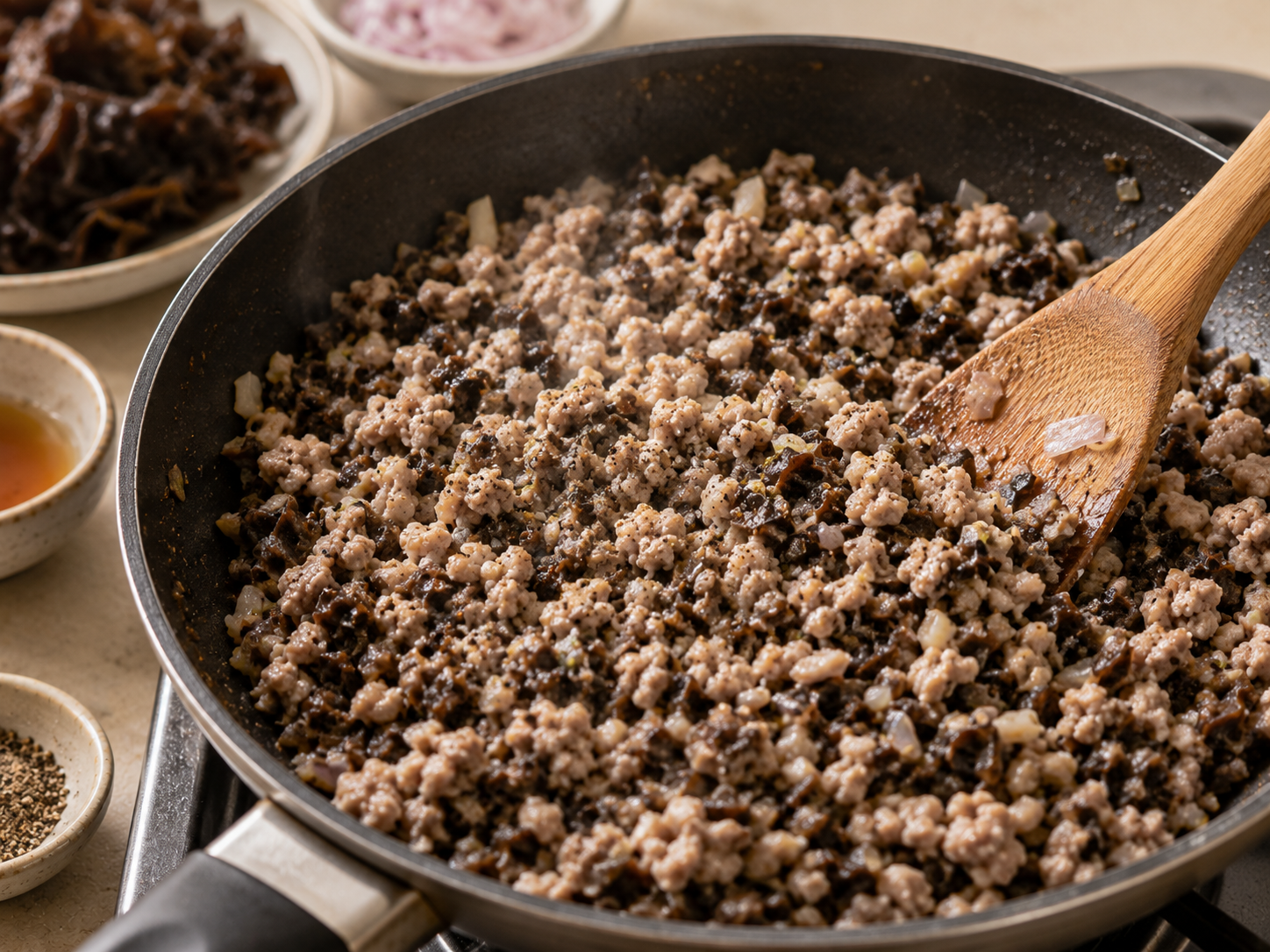 Ground pork and wood ear mushroom filling cooking with shallots and black pepper for bánh cuốn Vietnamese steamed rice rolls.